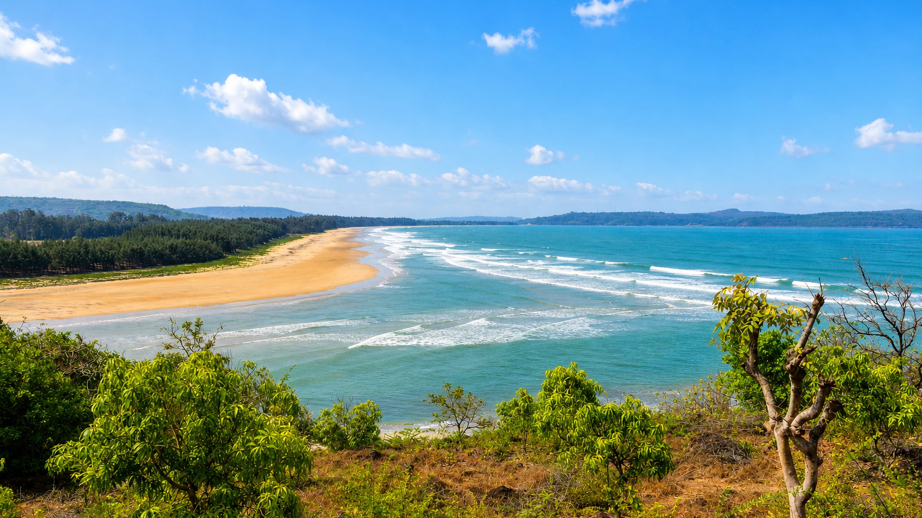 The Konkan coast at Ratnagiri, a long empty sand beach curving below wooded headlands.