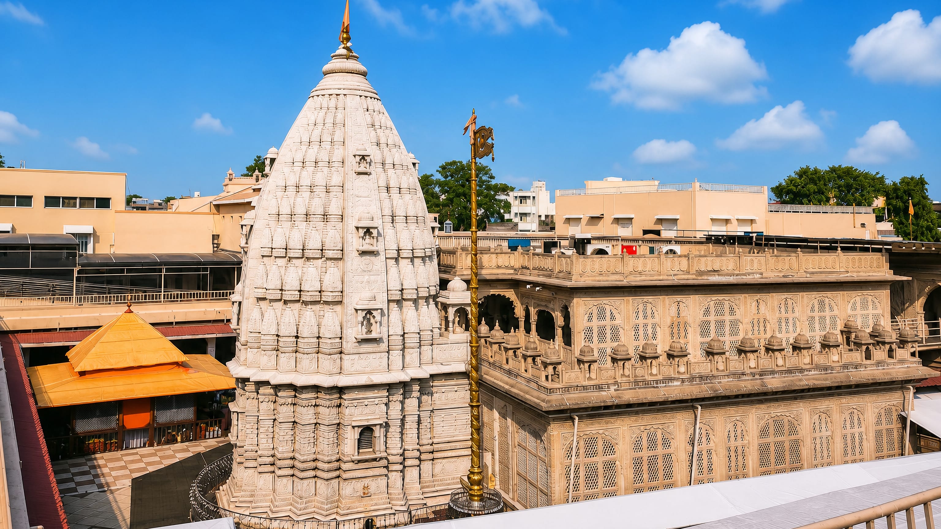 Carved white stone temple spire and colonnaded courtyard in the temple town of Shegaon, India