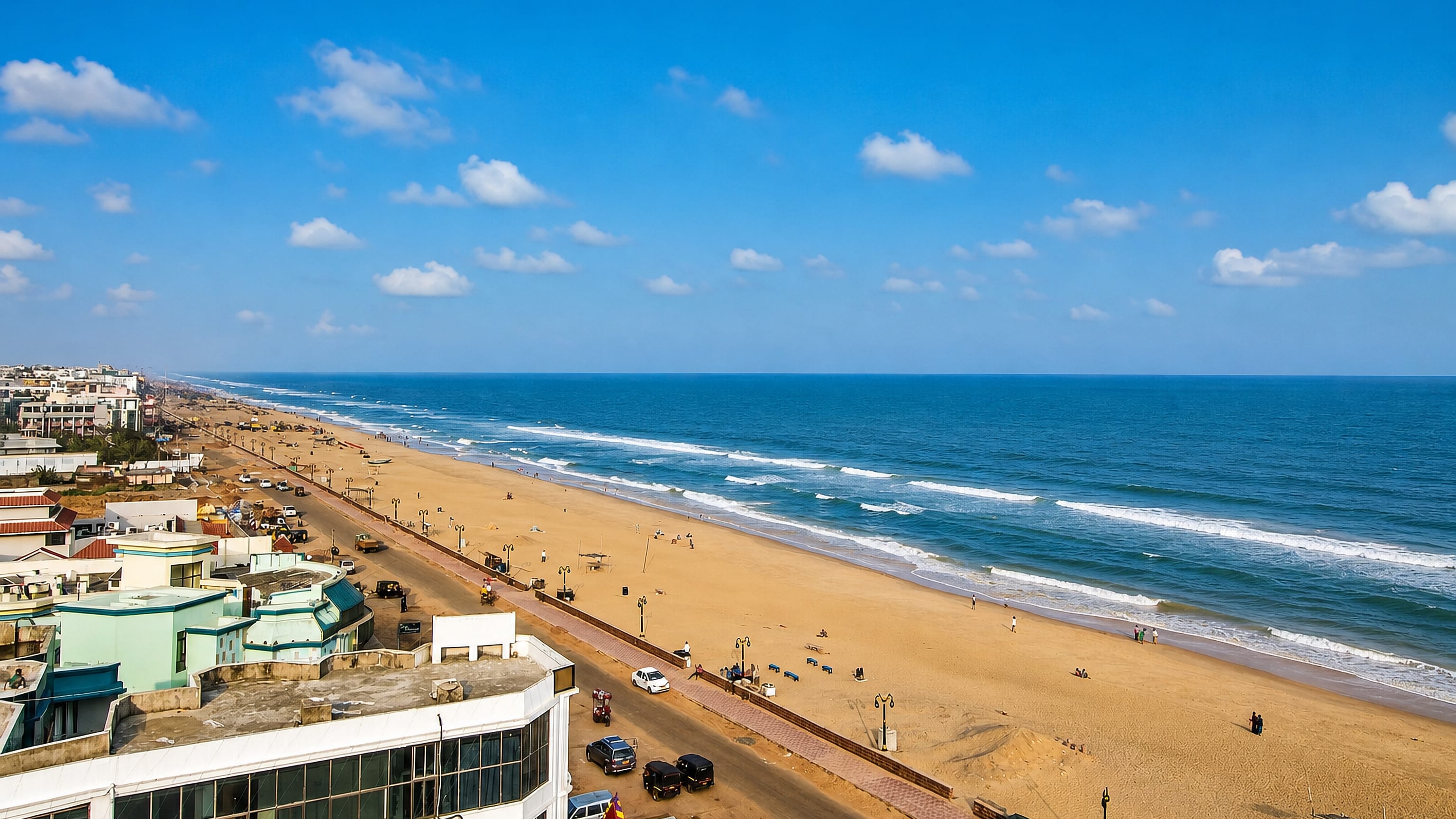 Wide golden beach and seafront road lined with hotels at Puri on India's Odisha coast.
