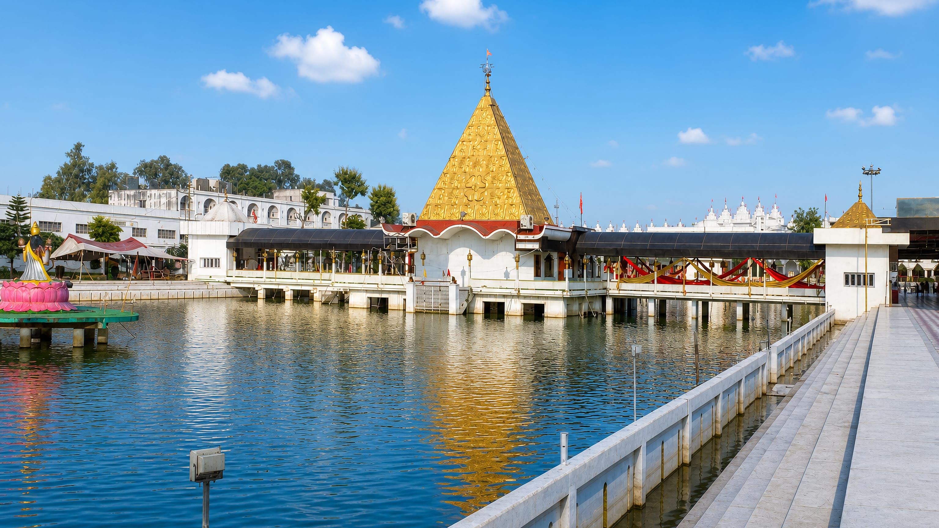 Devi Talab Mandir's golden shikhara mirrored in its sacred tank in Jalandhar, Punjab
