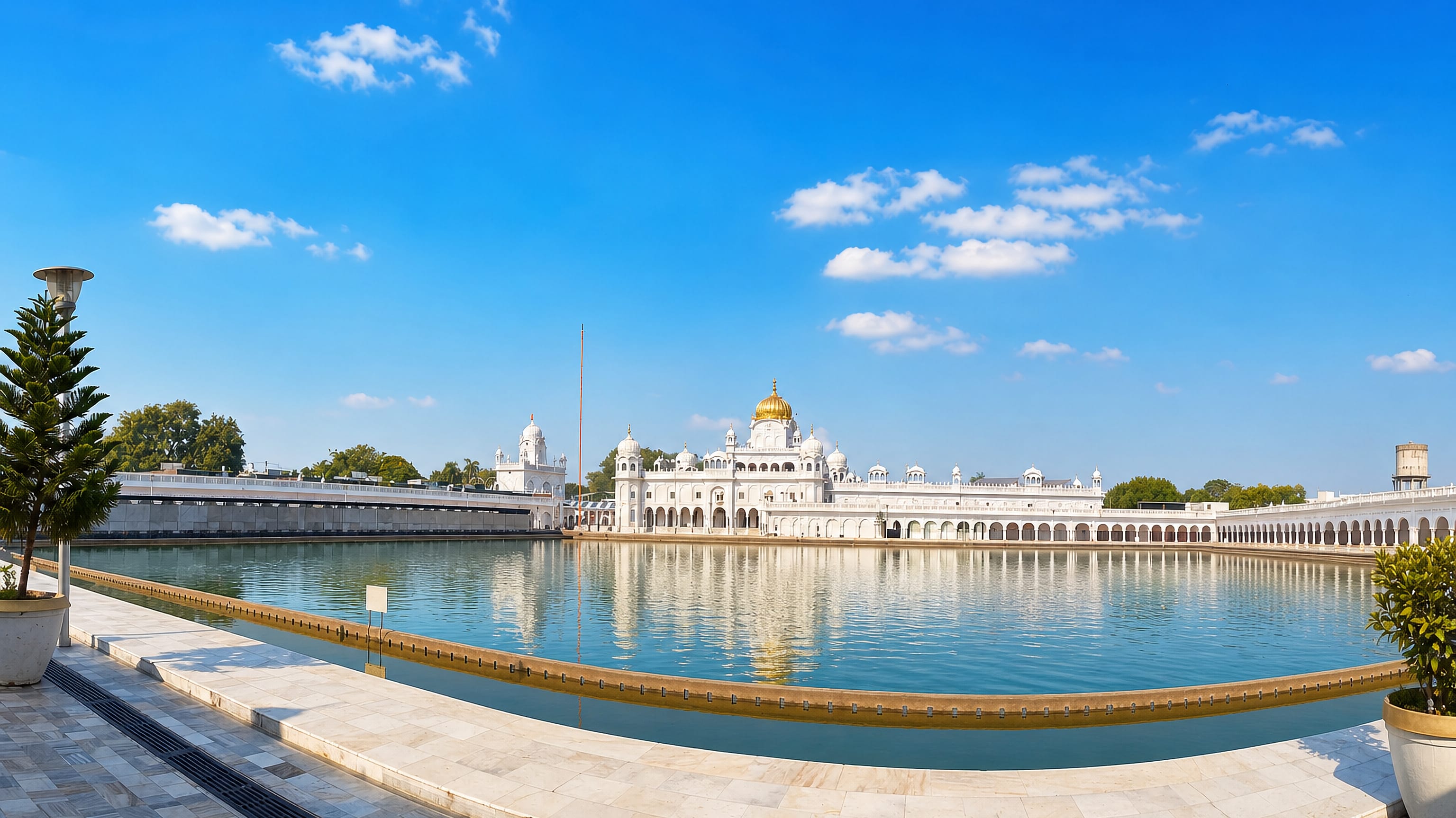 A white marble gurdwara with a golden dome mirrored in its sarovar in Patiala, Punjab, India.
