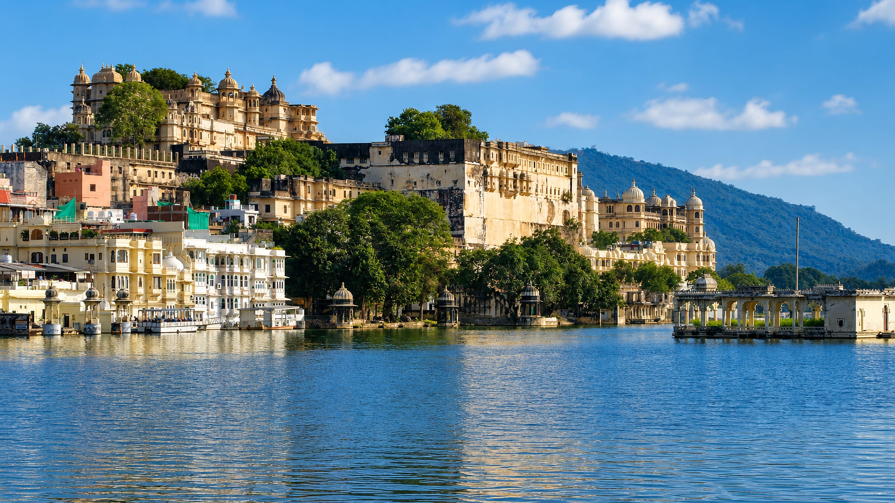 Udaipur's City Palace complex rising above Lake Pichola under a blue sky