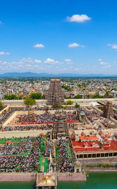 Aerial view of Madurai's Meenakshi Amman Temple, its towering gopurams and sacred tank amid the city.