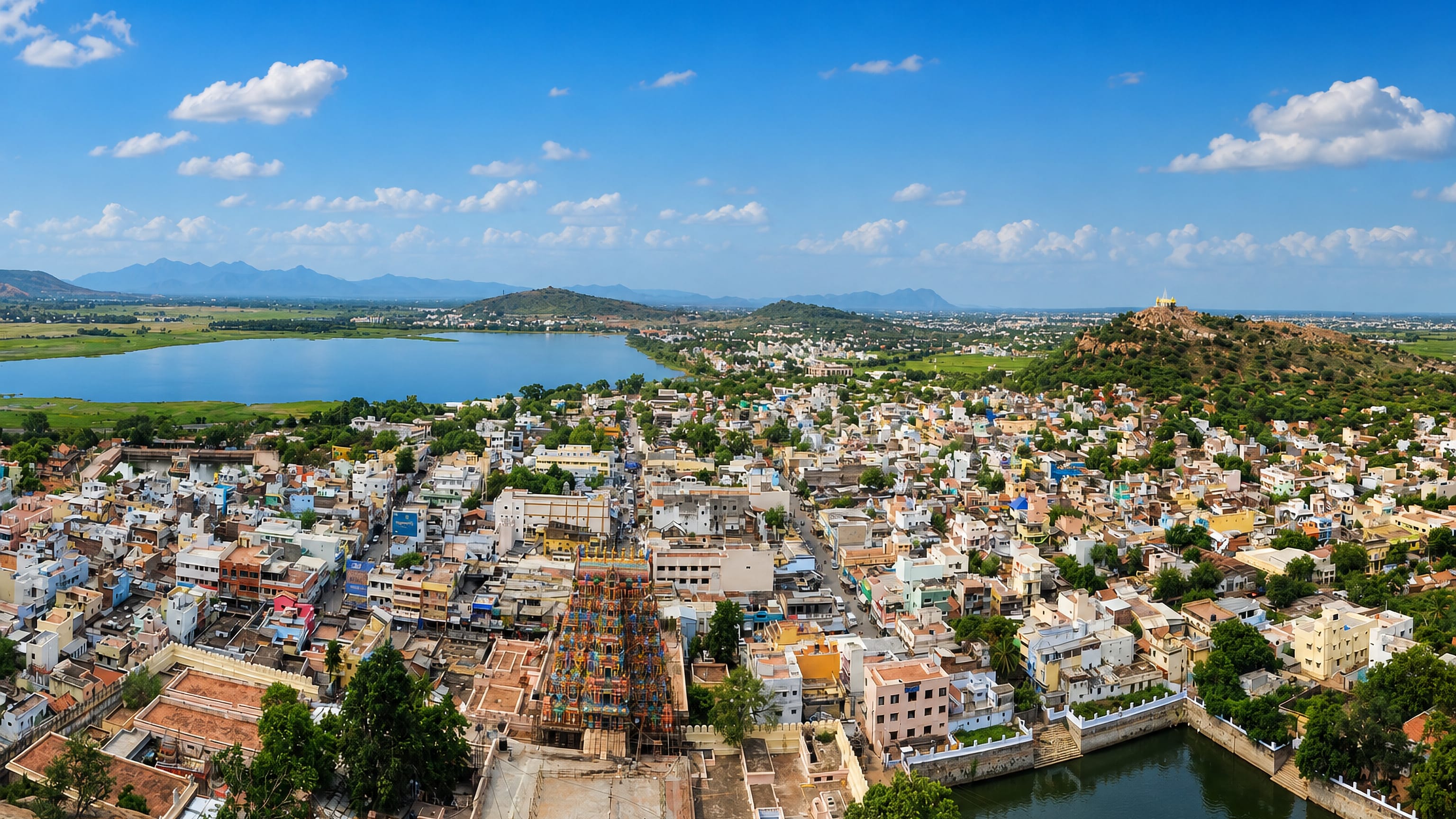 Tirupparangunram, India, from the temple hill: painted gopuram, temple tank and lake beyond.
