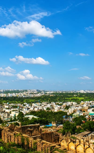 Golconda Fort ruins in the foreground with the Hyderabad cityscape stretching to the horizon.