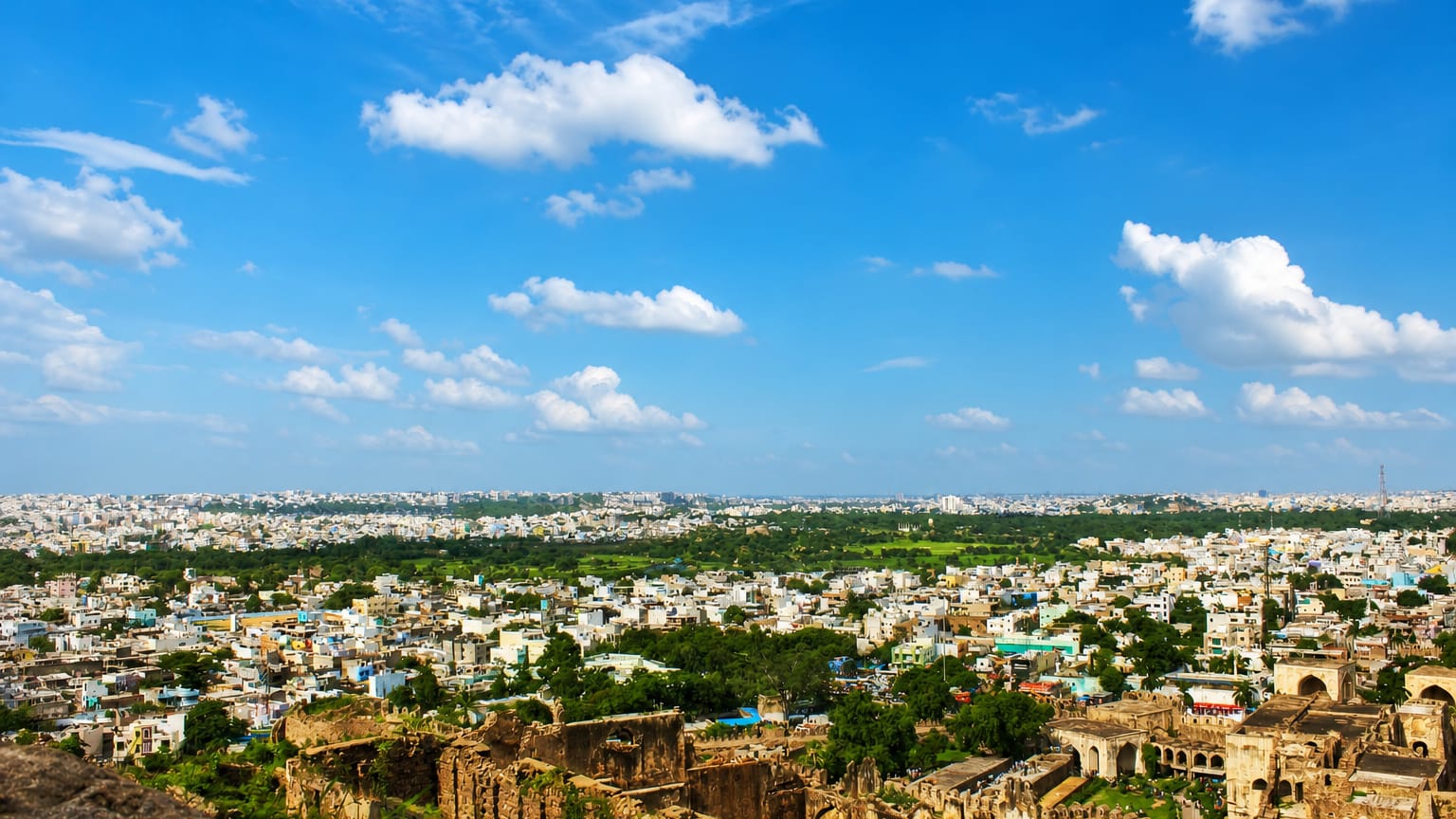 Golconda Fort ruins in the foreground with the Hyderabad cityscape stretching to the horizon.