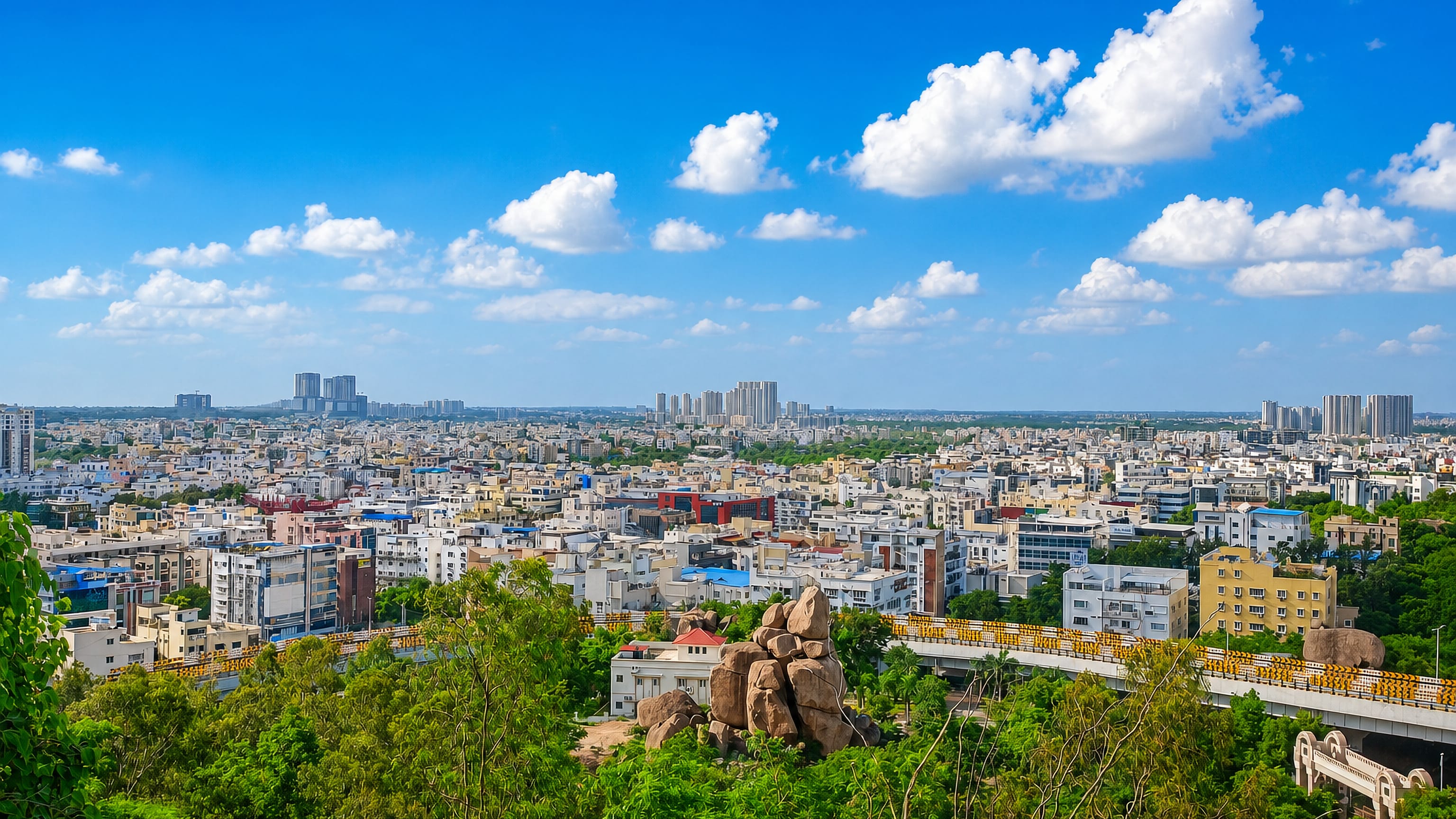 Granite boulder outcrops and an elevated flyover above the low-rise sprawl of Jubilee Hills, Hyderabad.