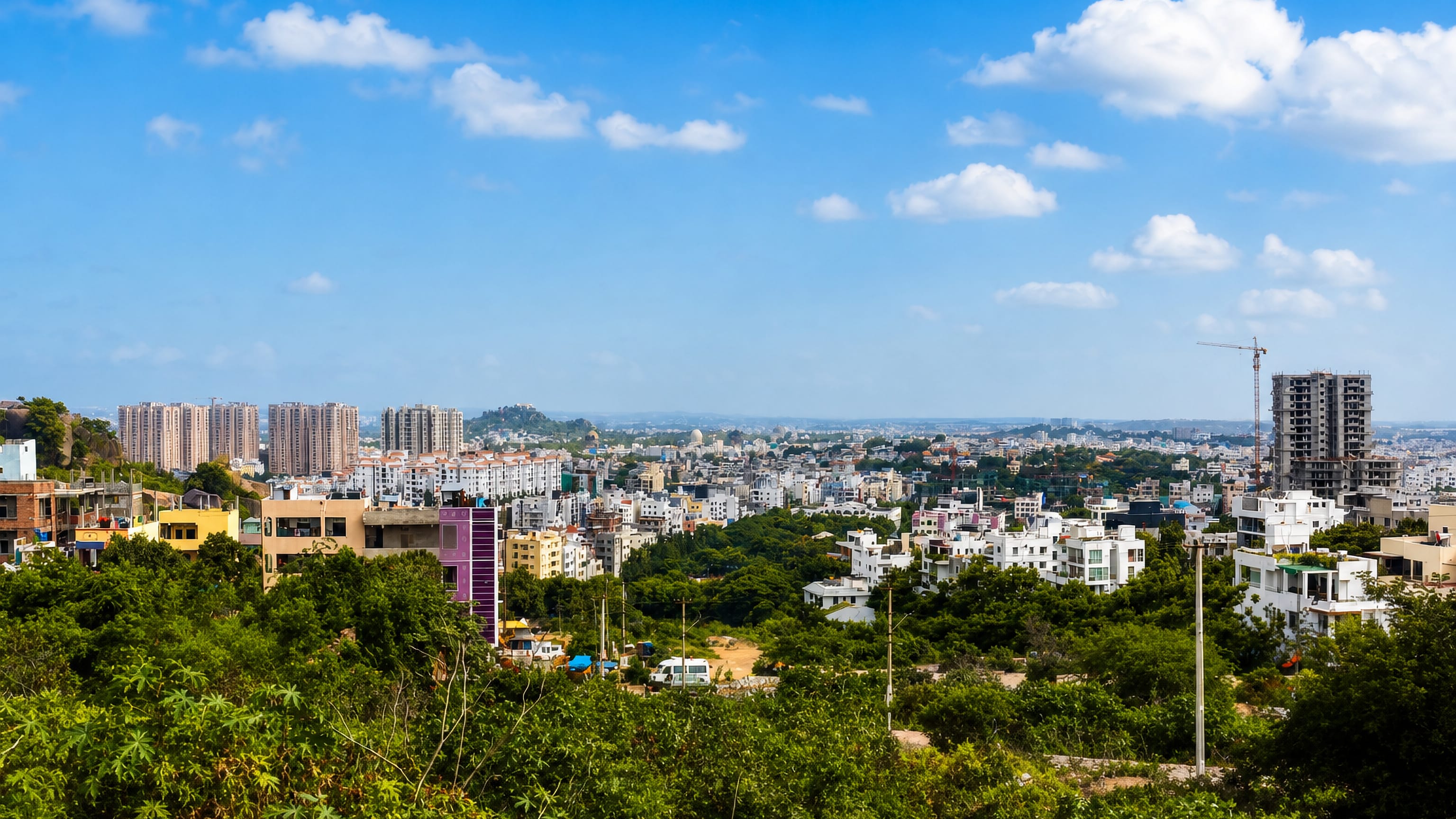 Hillside view over low-rise houses, mosque domes and rocky outcrops in Tolichowki, Hyderabad