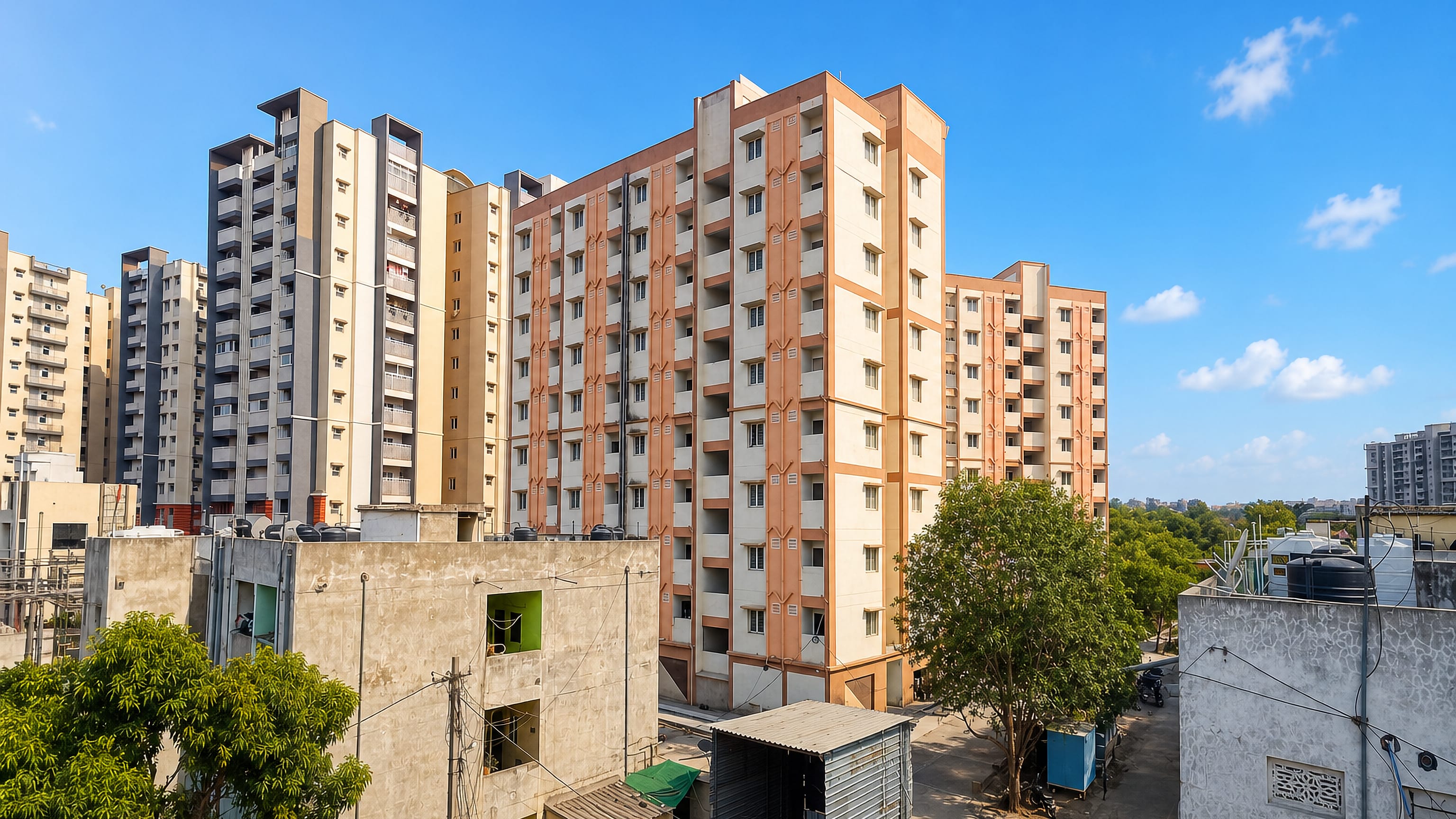 Mid-rise apartment blocks with rooftop water tanks in Kukatpally, Hyderabad, India, under a clear sky.