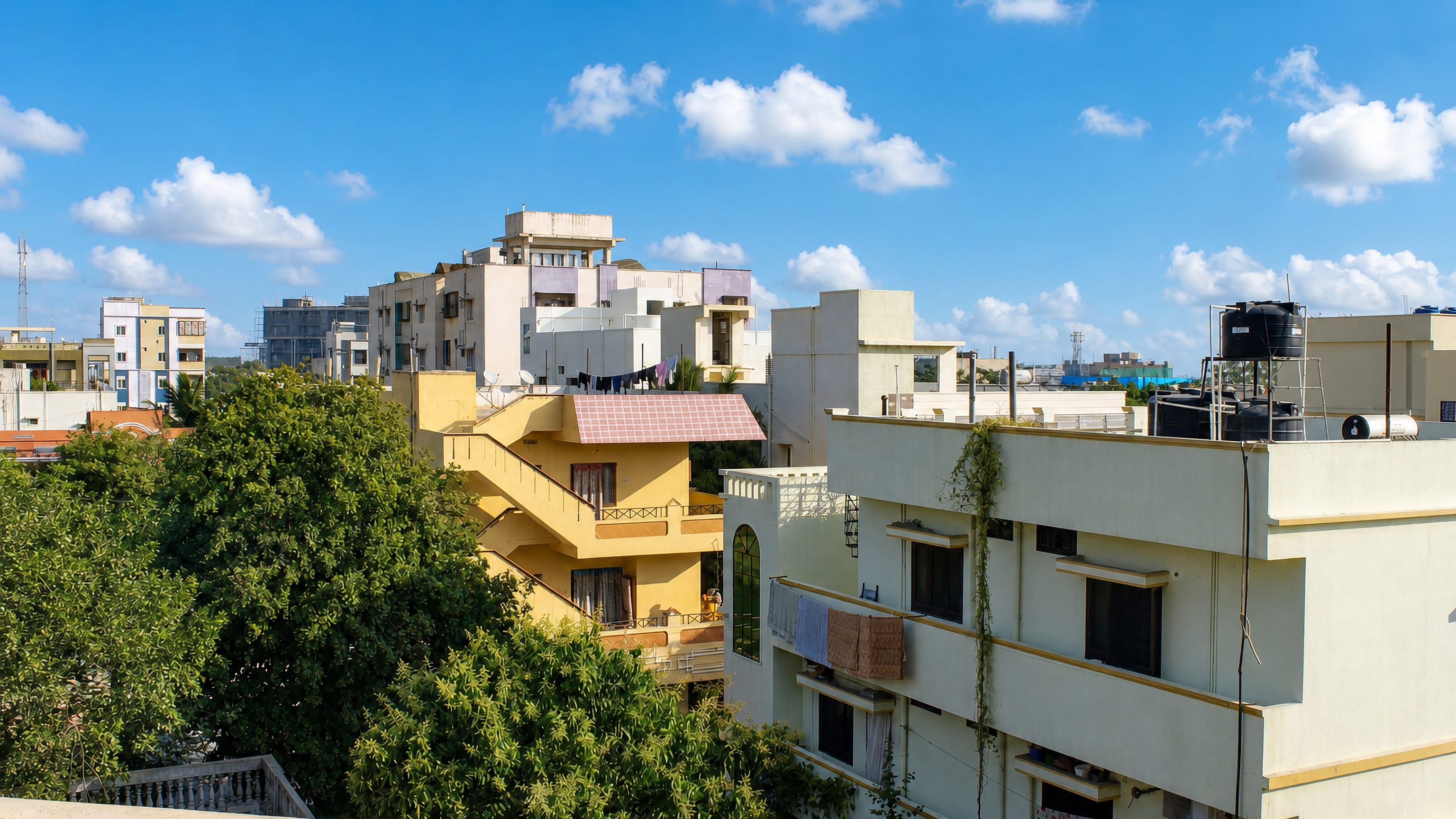 Rooftops, water tanks and low apartment blocks under a blue sky in Lal Bahadur Nagar, Hyderabad.
