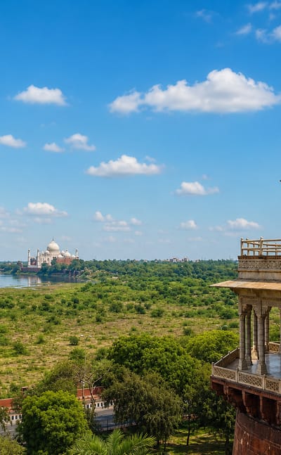 The Taj Mahal across the Yamuna river seen from an ornate Mughal marble pavilion at Agra Fort