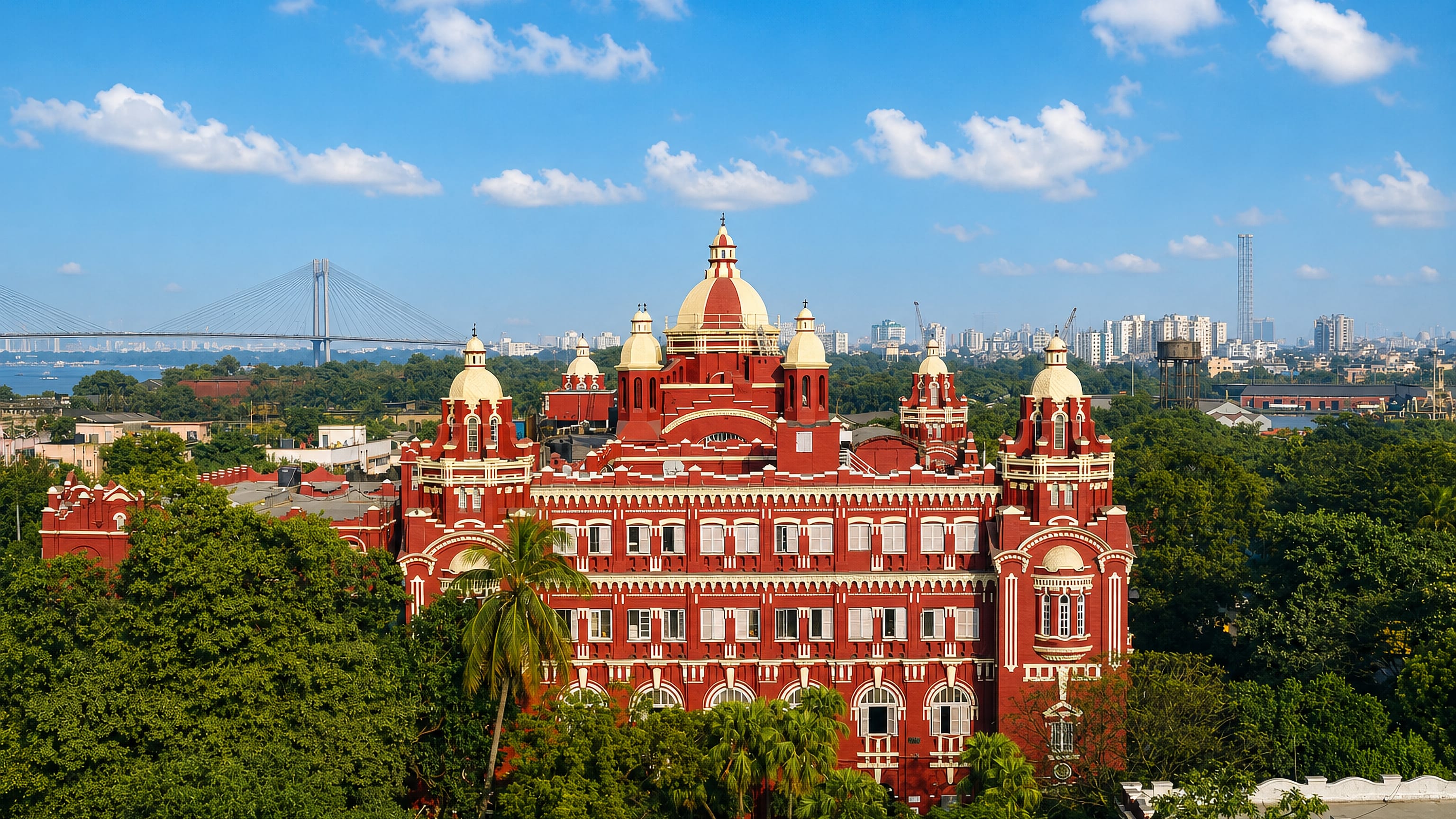 Red-brick domed colonial landmark above the trees of Garden Reach, Kolkata, with a cable-stayed bridge on the Hooghly
