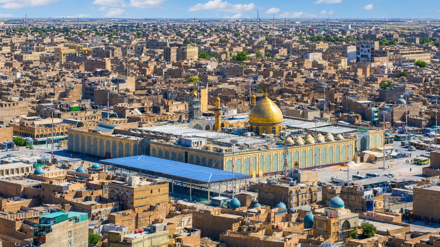 Aerial view of Najaf, Iraq, centred on the Imam Ali Shrine's golden dome and minarets amid the old city.