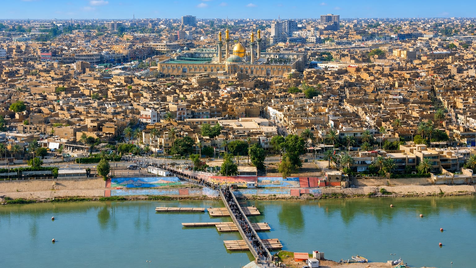Golden domes and minarets of the Al-Kadhimiya Shrine rising over Baghdad's Kadhimiya district beside the Tigris