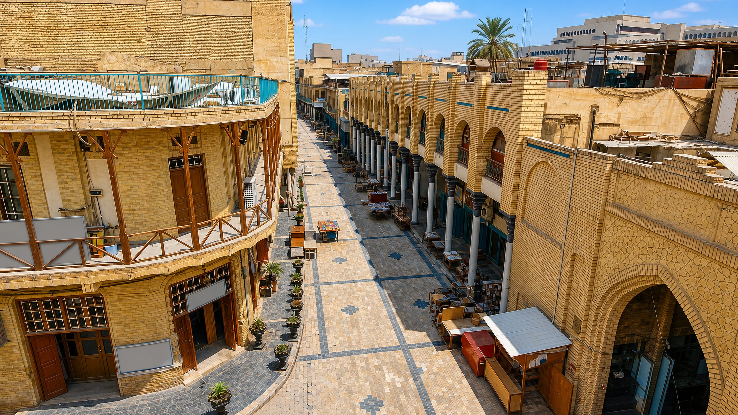 Arcaded ochre-brick buildings and book stalls lining Mutanabbi Street in Baghdad on a clear day.