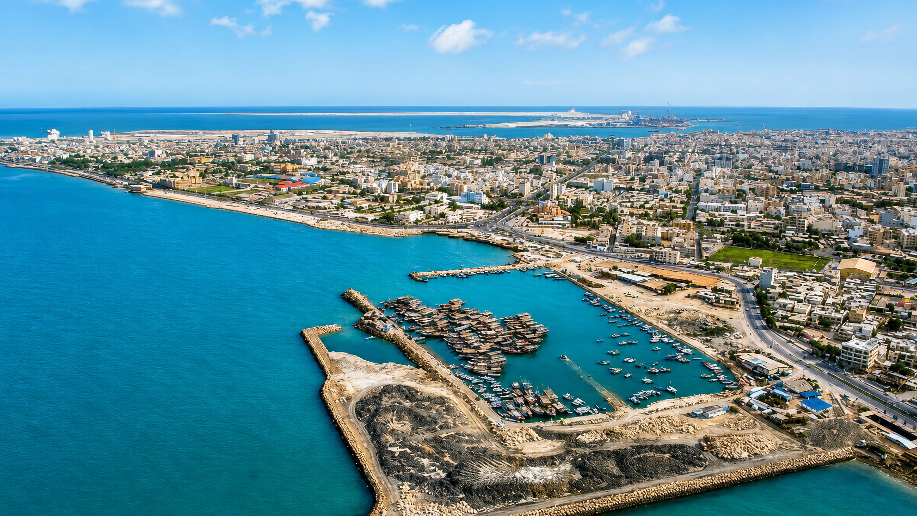 Aerial view of Bushehr, Iran, a Persian Gulf peninsula city with a breakwater-sheltered fishing harbour of dhows