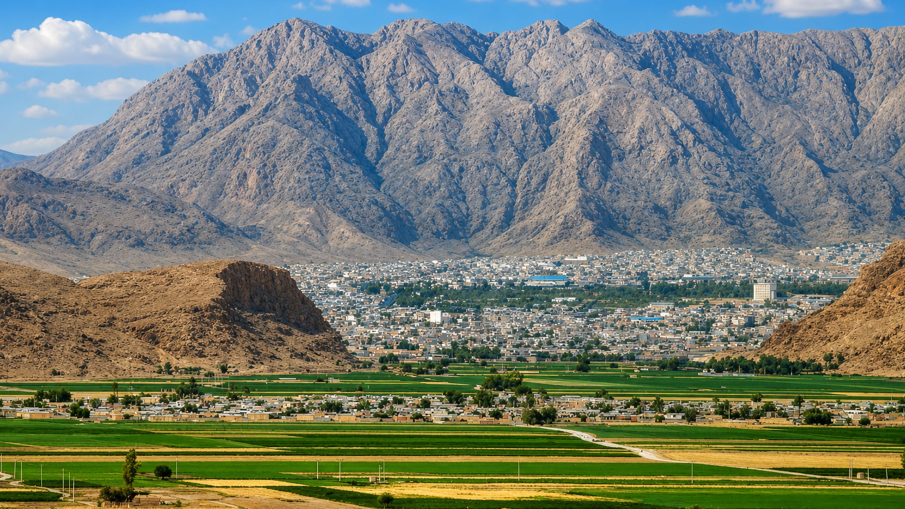 Darab, Iran, spread on its farmland plain below a long rocky mountain wall