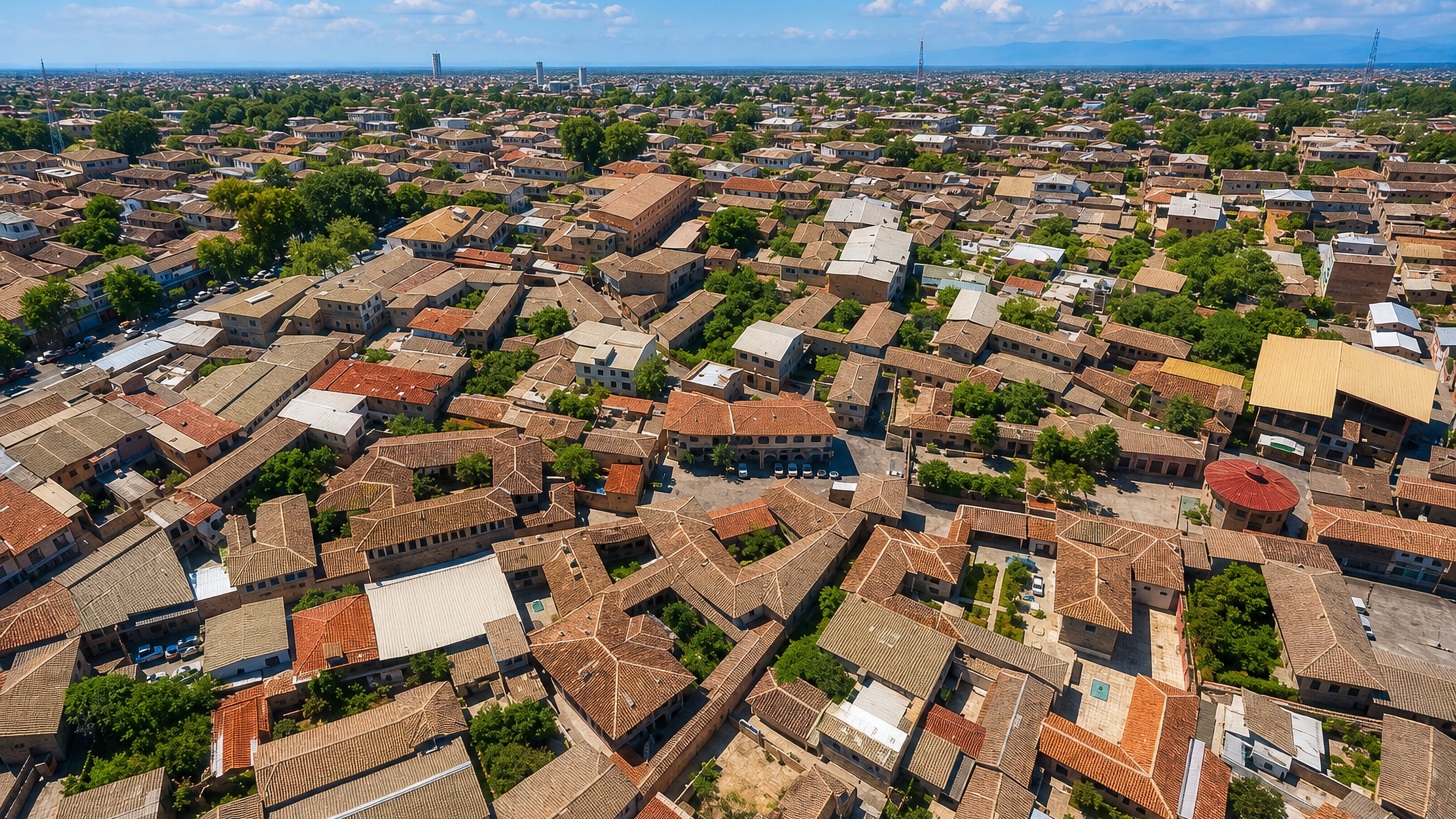 Tiled rooftops and walled courtyards of Gorgan's old quarter in northern Iran spread out under a clear sky.