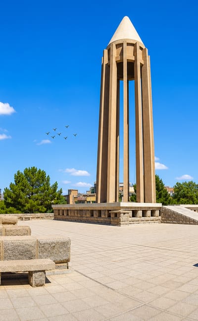 The conical Avicenna Mausoleum monument rising above its stone plaza in Hamadan.