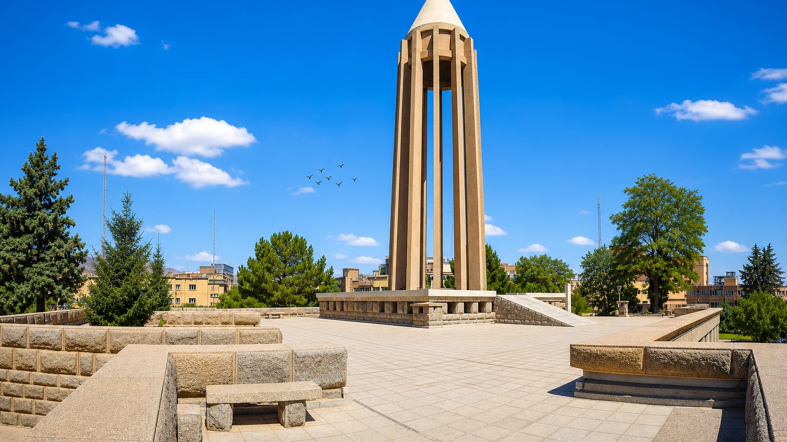 The conical Avicenna Mausoleum monument rising above its stone plaza in Hamadan.