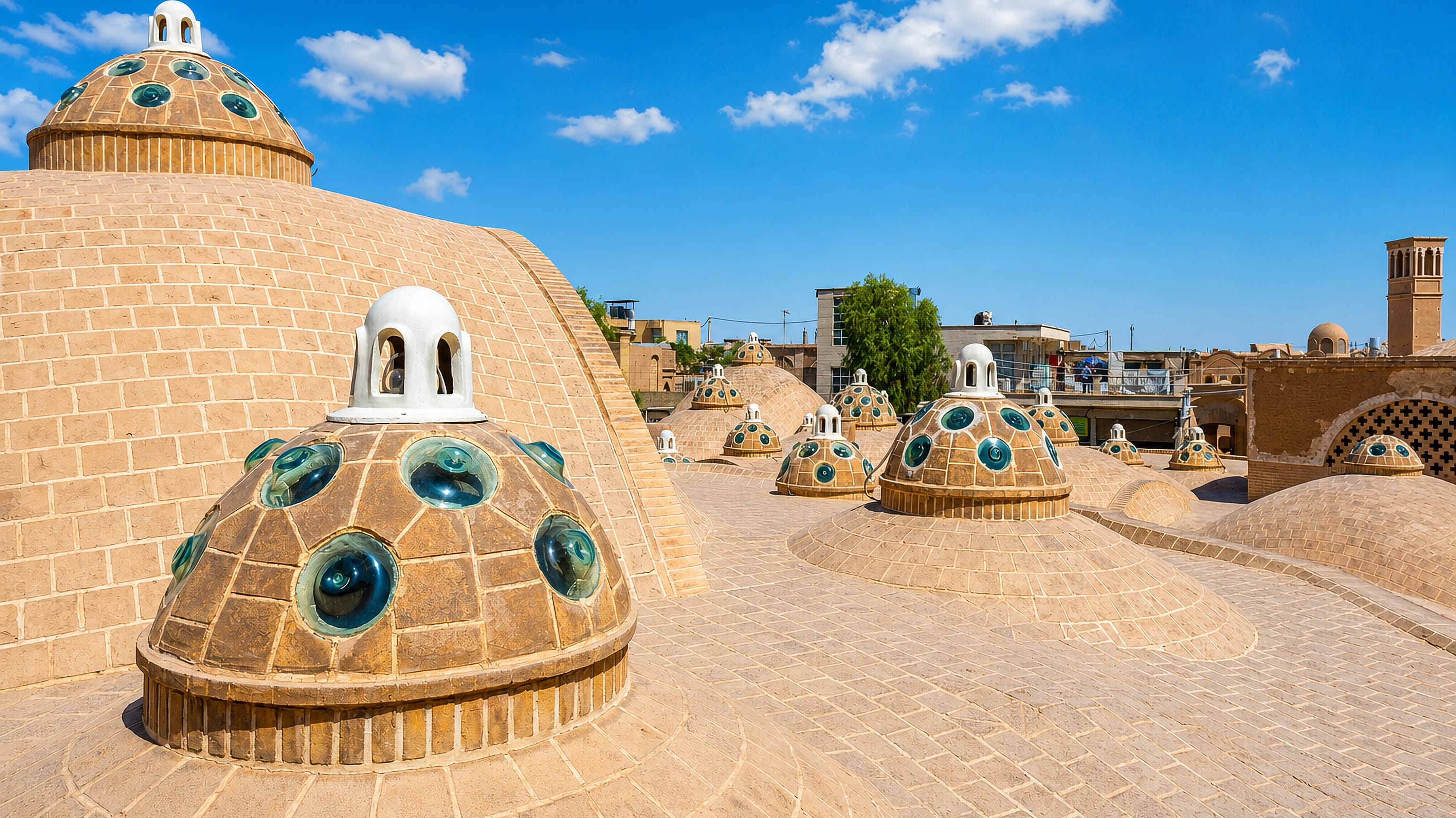 Domed rooftop of Kashan's Sultan Amir Ahmad Bathhouse, its convex glass skylights above the old town.