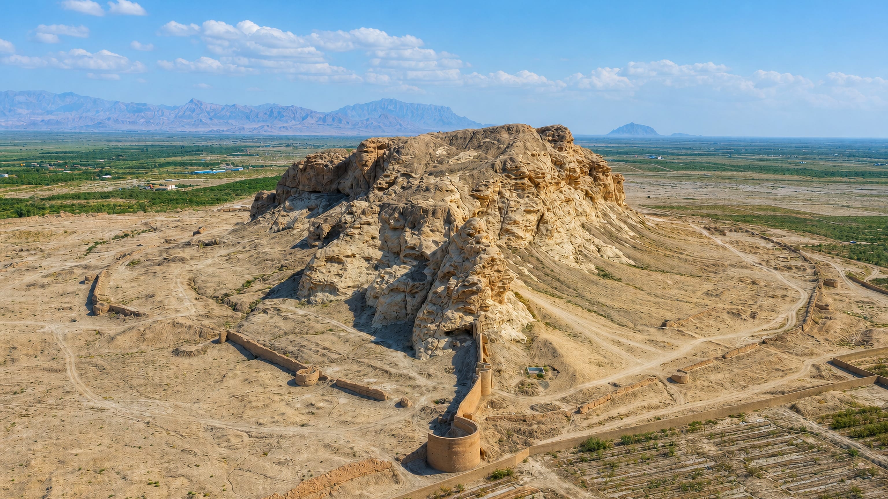 The eroded mudbrick citadel mound of Qal'eh Sang on the plain outside Sirjan, Iran.