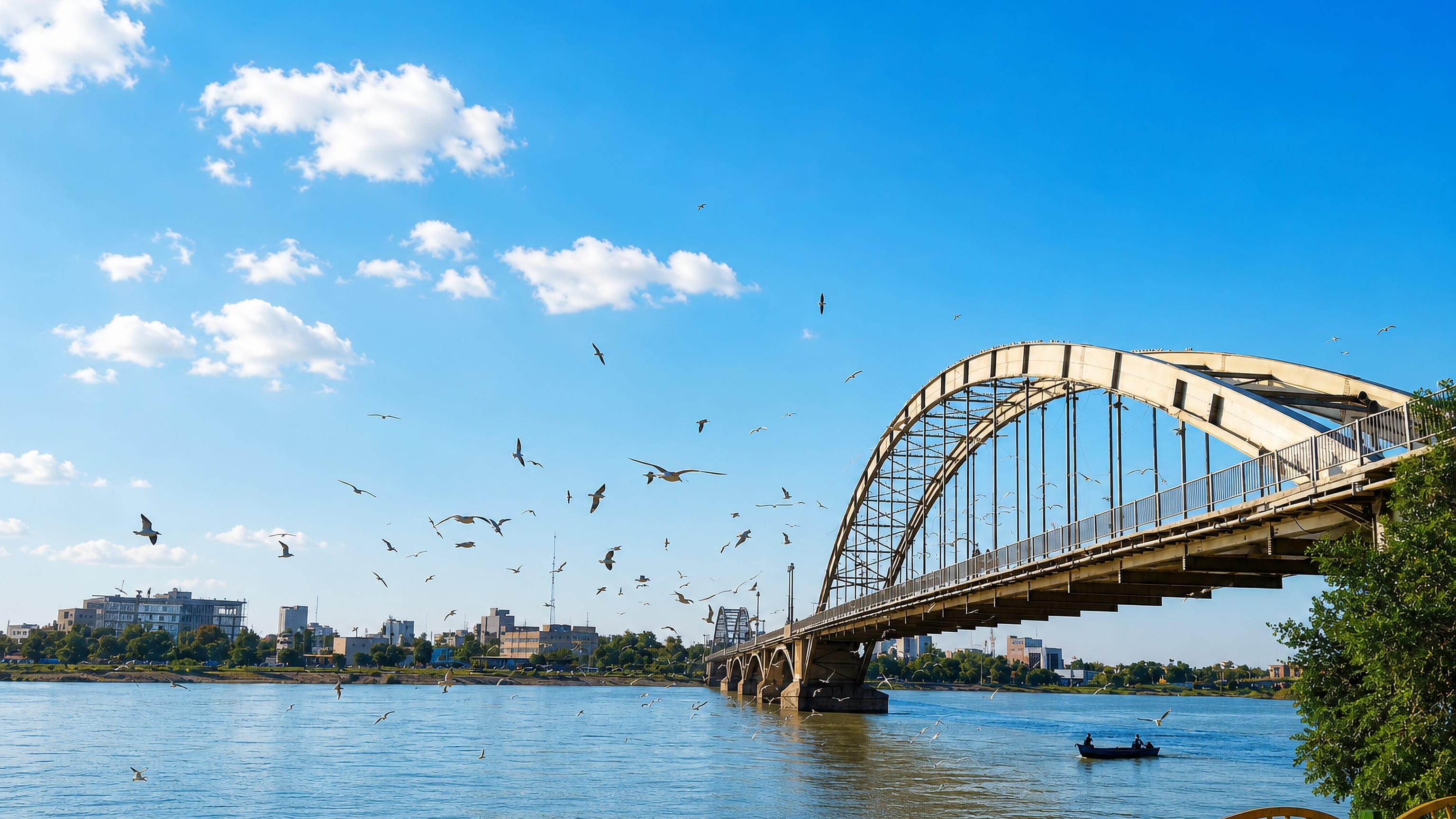 Ahvaz's white arched bridge over the Karun River with birds wheeling above the water.
