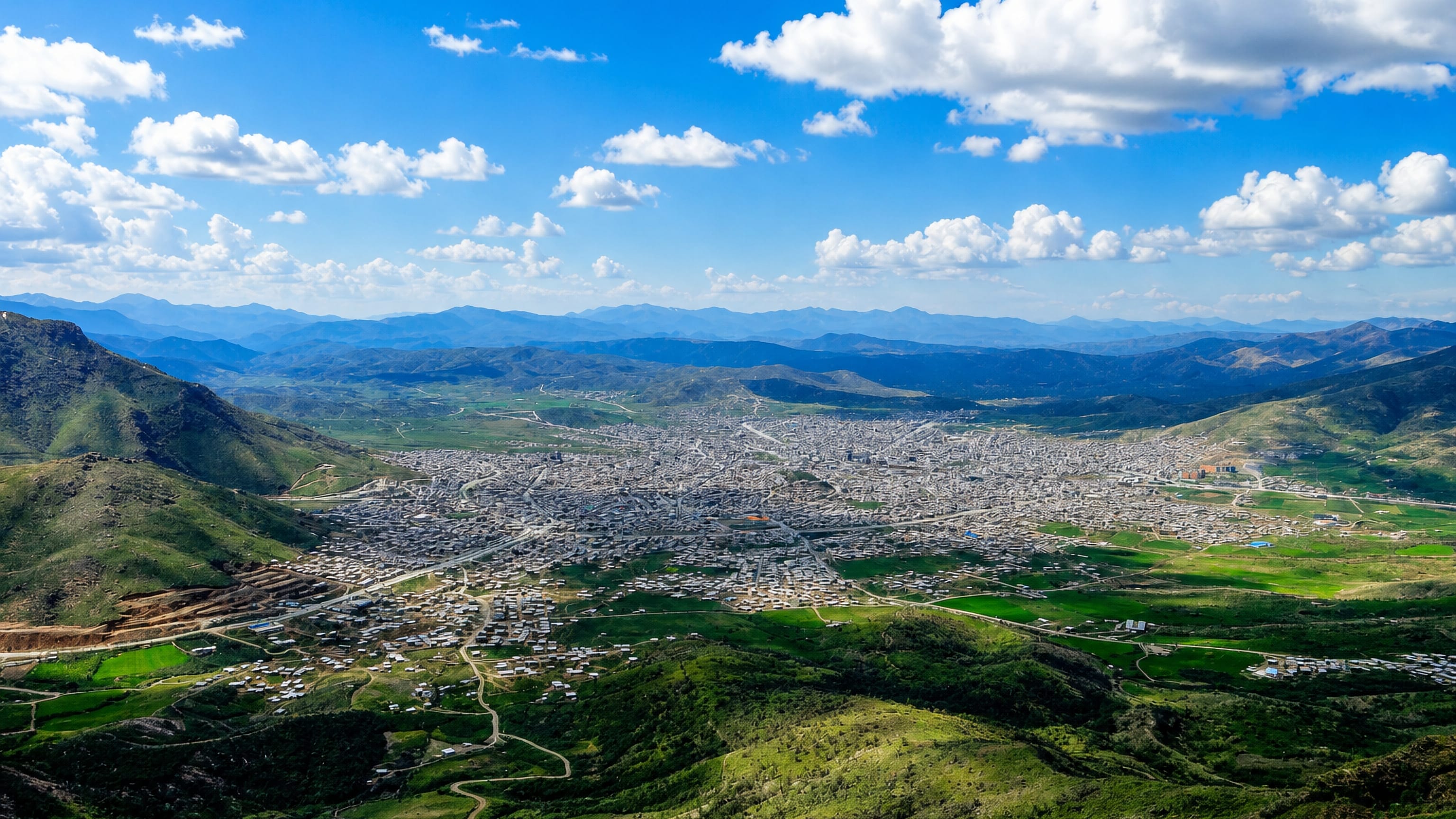 Bāneh spread across a broad green valley ringed by the Zagros mountains in Iran's Kurdistan province.