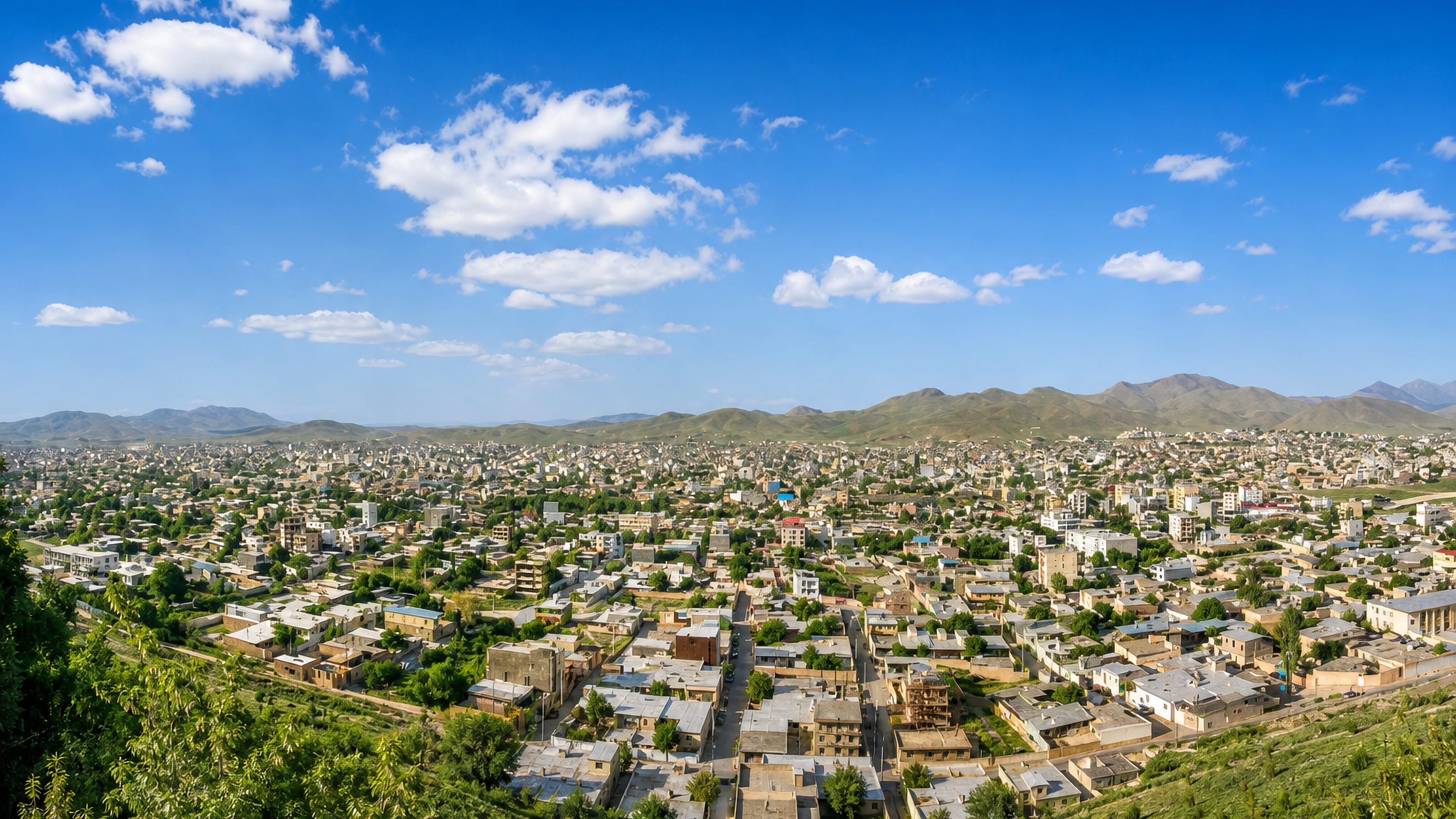 Hillside view over the flat-roofed houses of Aligudarz, Iran, ringed by the Zagros mountains