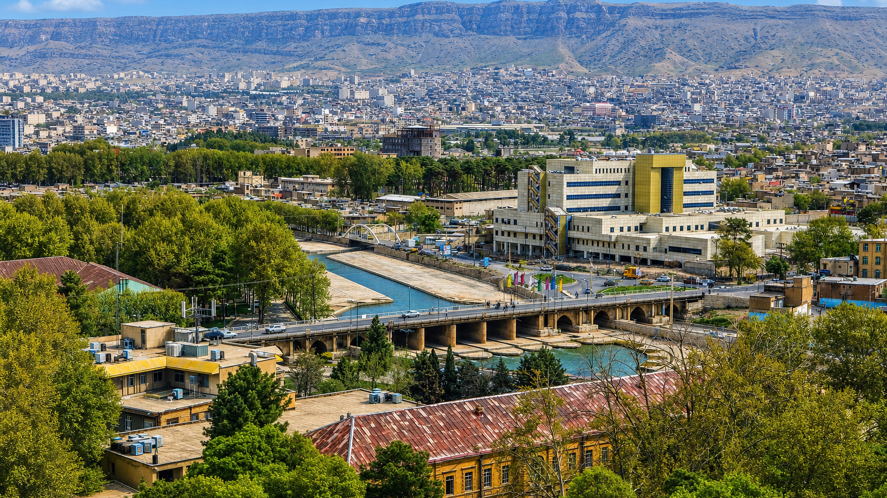 Khorramabad spreading along its river and stone bridge beneath the Zagros ridges of Lorestan.