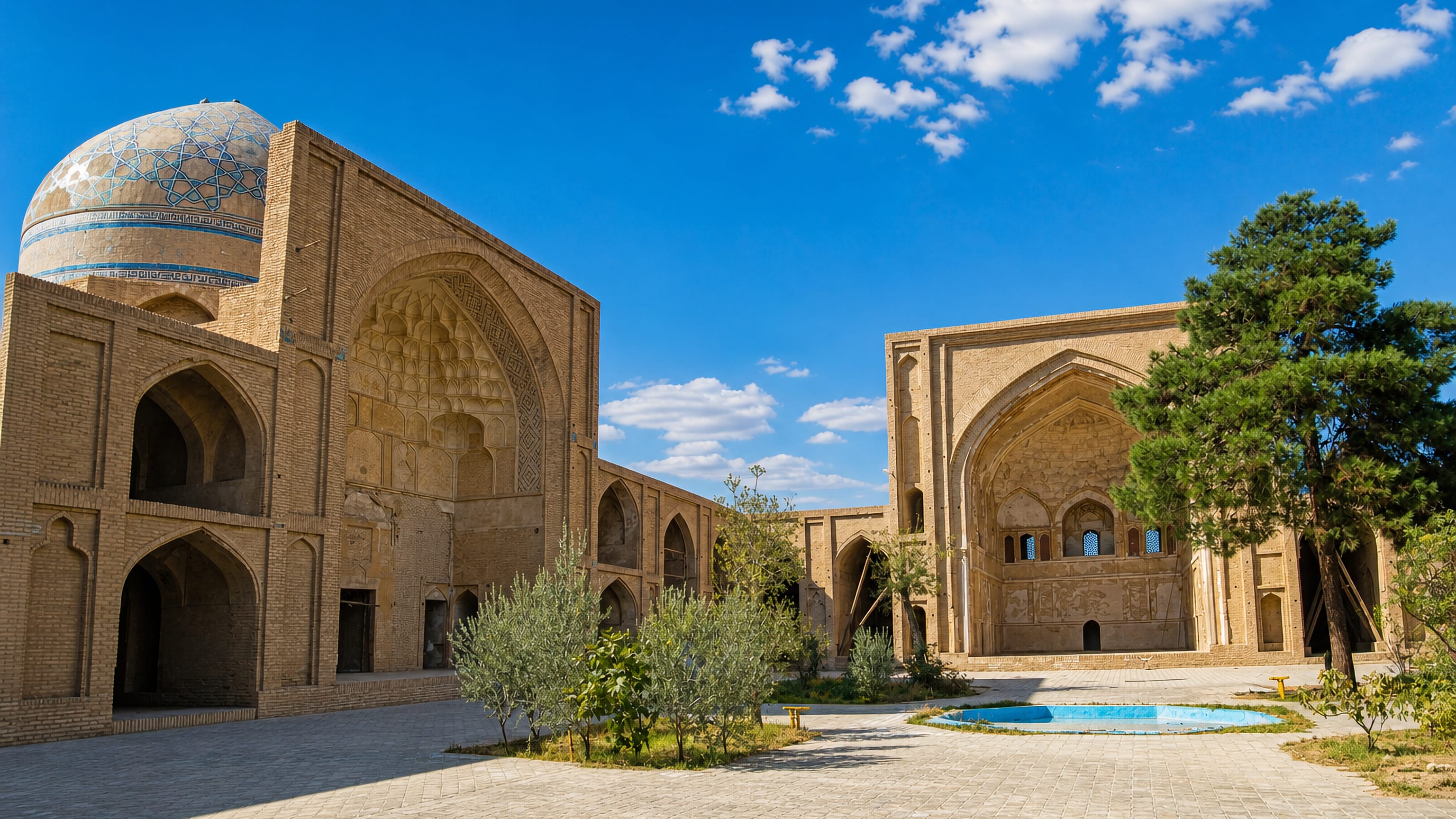Brick iwans and a turquoise-tiled dome around the courtyard of the historic Friday Mosque in Saveh, Iran.