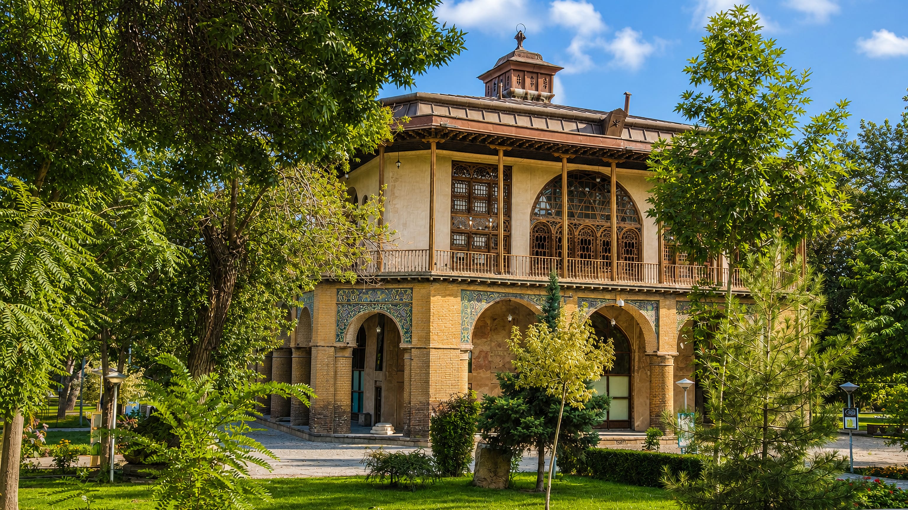 Safavid-era Chehel Sotoun pavilion in Qazvin, Iran, its tiled arcade and wooden veranda framed by park trees.