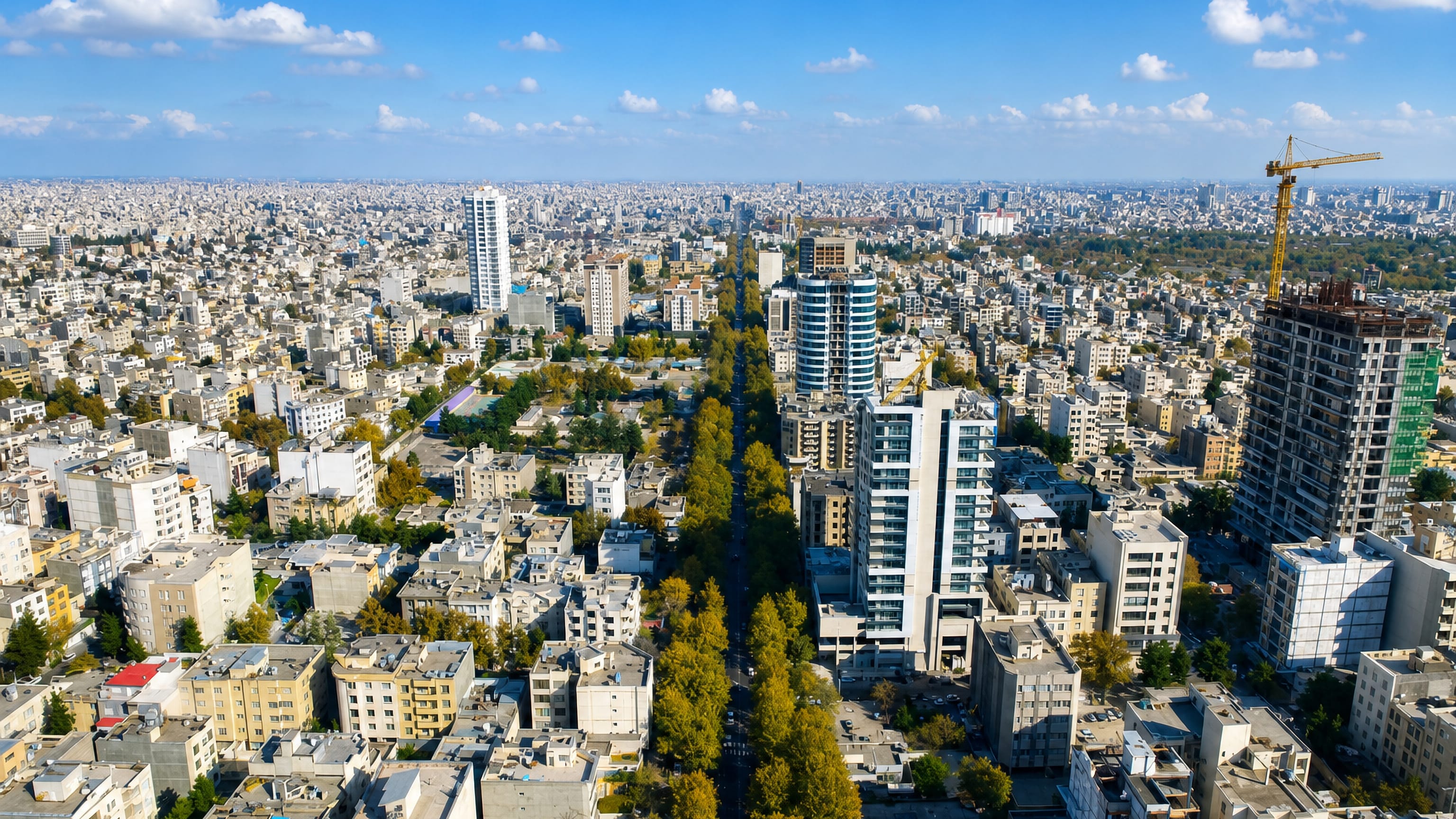 Aerial view over Sanabad in Mashhad, Iran, with a tree-lined avenue cutting through dense apartment blocks