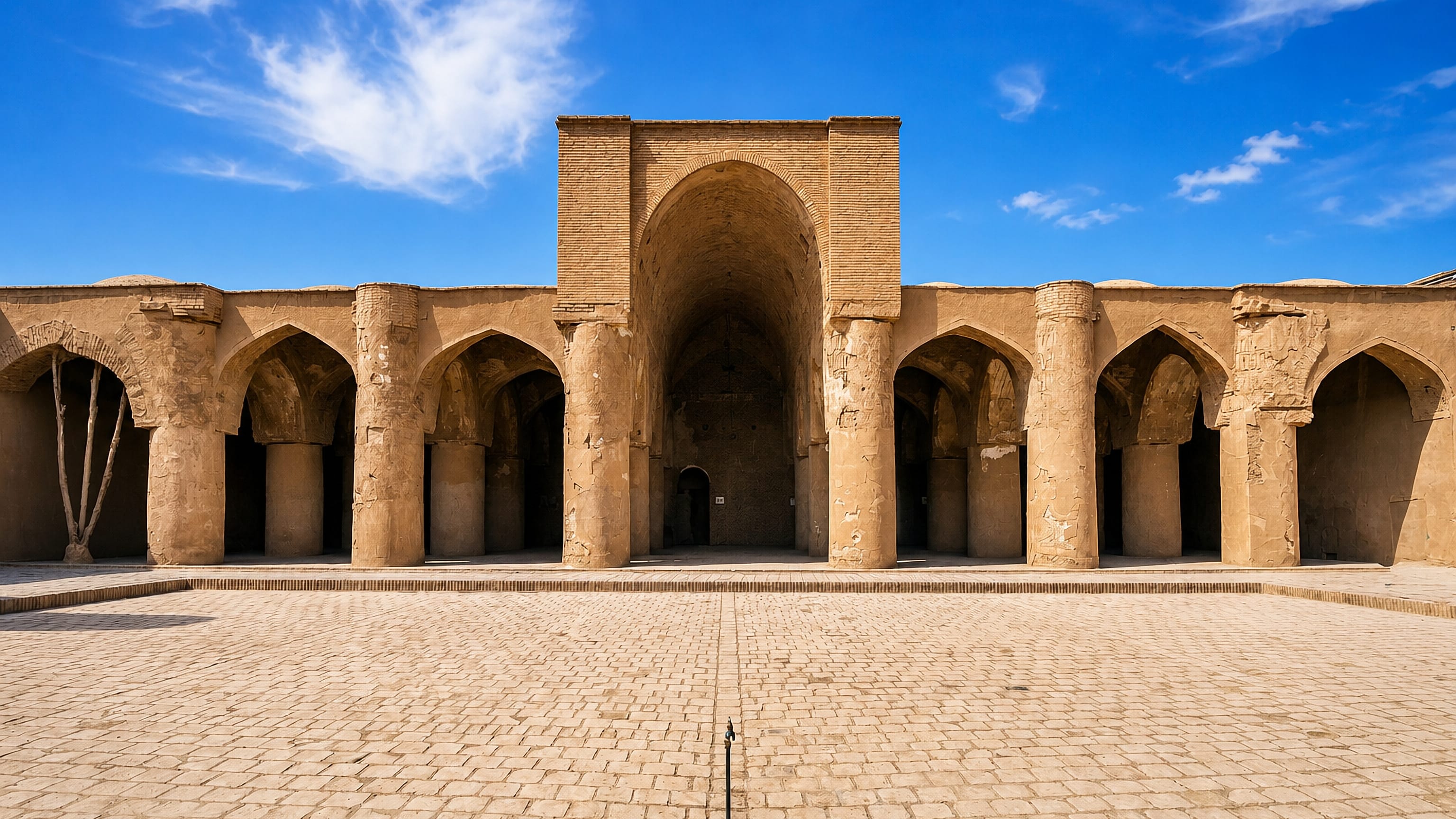 Brick piers and the tall arched iwan of the Tarikhaneh Mosque courtyard in Damghan, Iran.