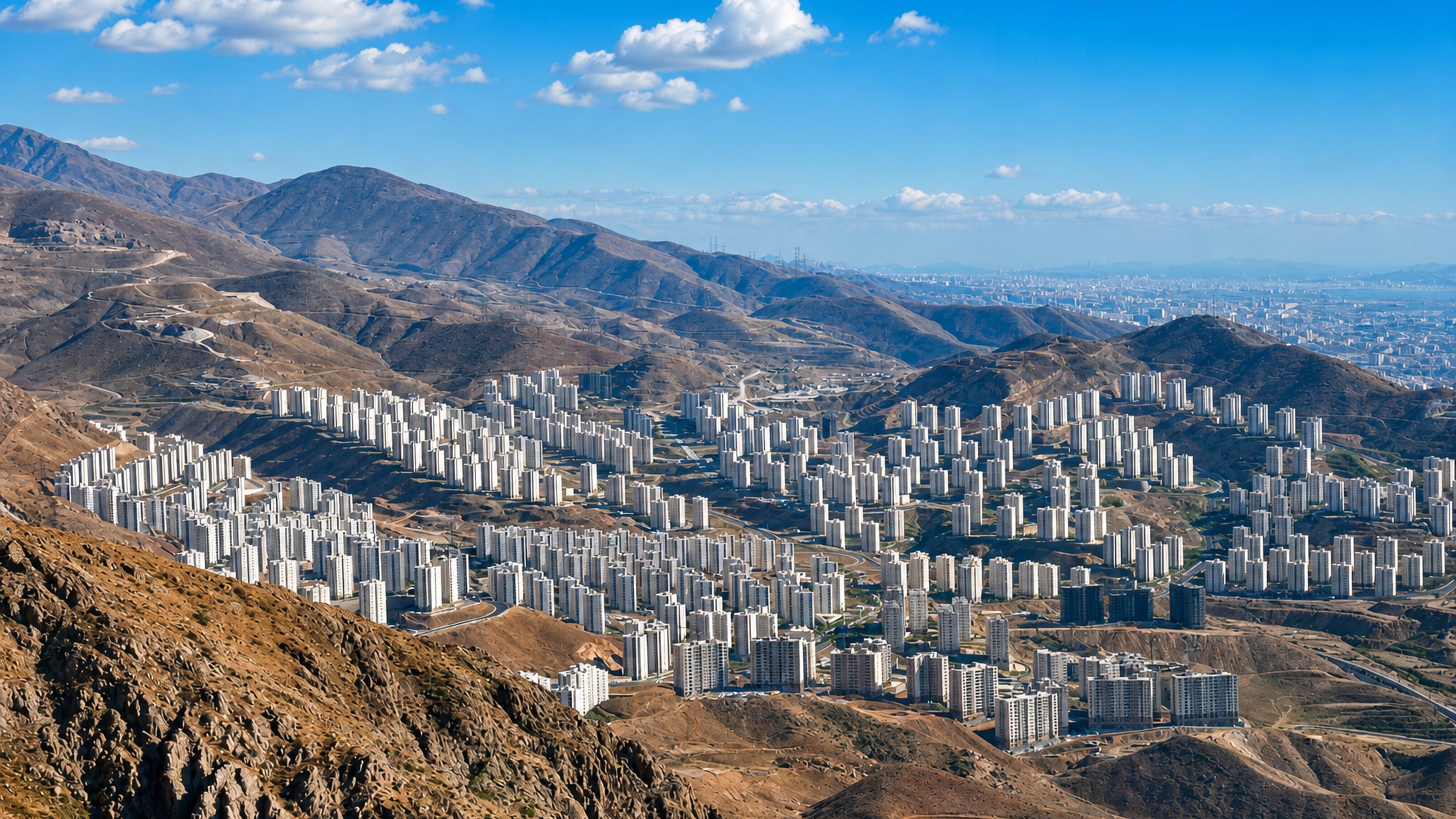 White apartment towers of the new town of Pardis spreading across arid Alborz foothills near Tehran.