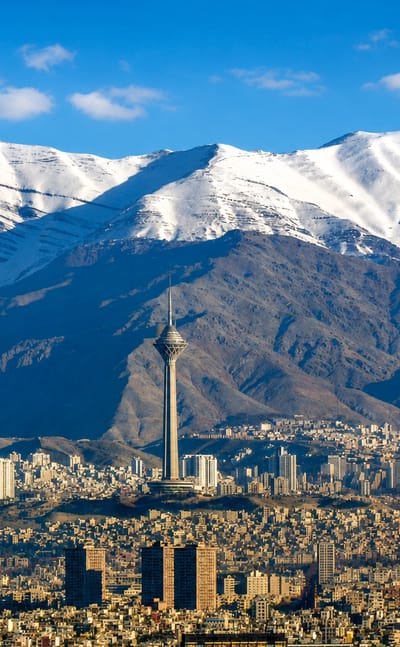 Snow-capped Alborz Mountains behind Tehran's skyline with the Milad Tower rising at the centre