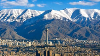 Snow-capped Alborz Mountains behind Tehran's skyline with the Milad Tower rising at the centre