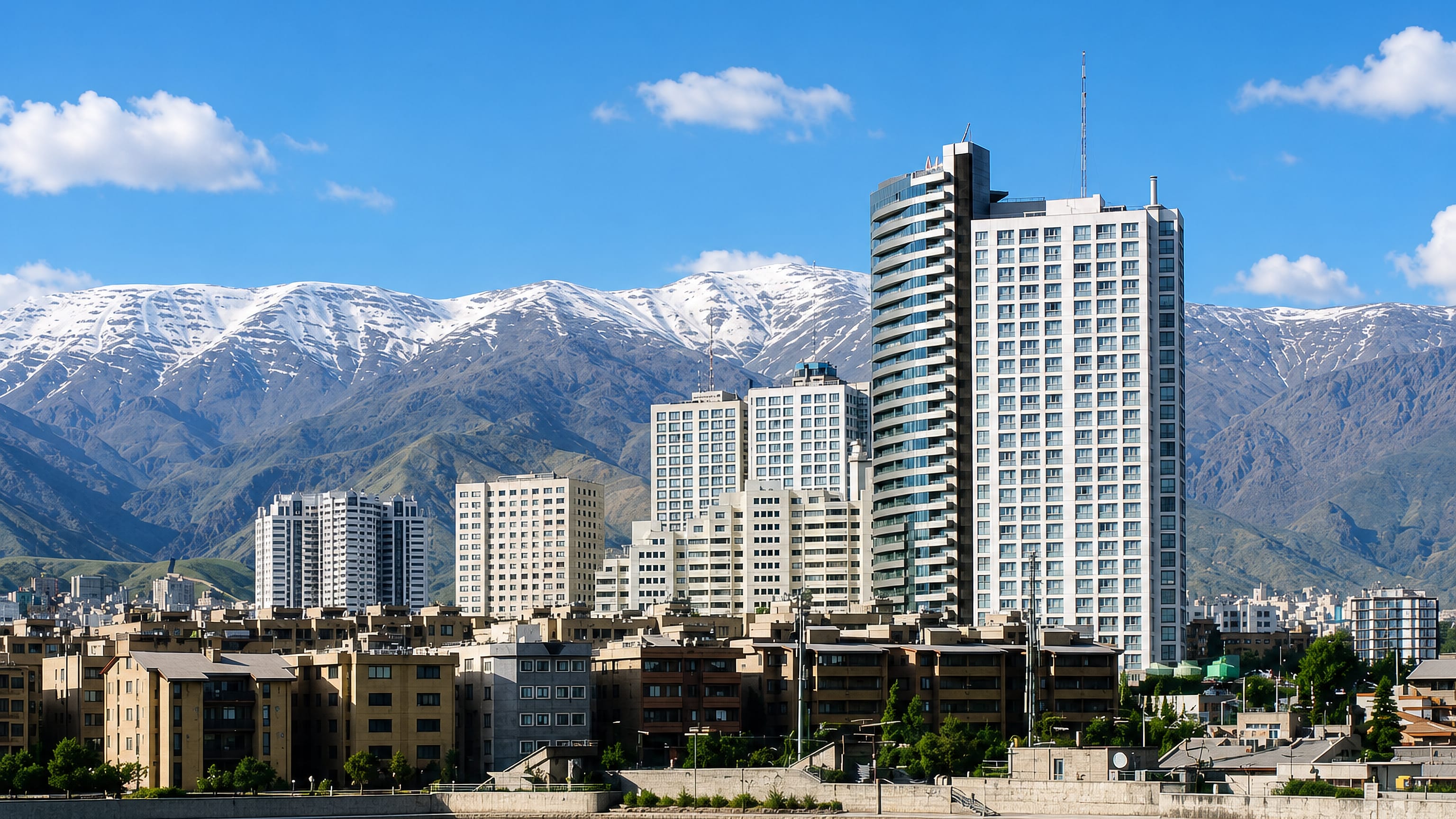 High-rise towers and apartment blocks below the snow-capped Alborz range near Shahrak-e Qods, Tehran.