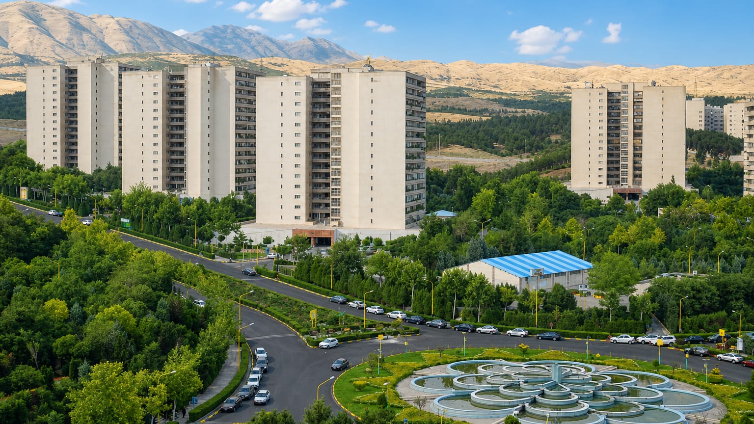 Beige residential tower blocks below the arid Alborz mountains with a landscaped fountain in Tehranpars, Tehran
