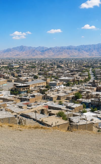 Flat-roofed houses of Piranshahr, Iran, spreading across a valley toward the arid Zagros mountains.