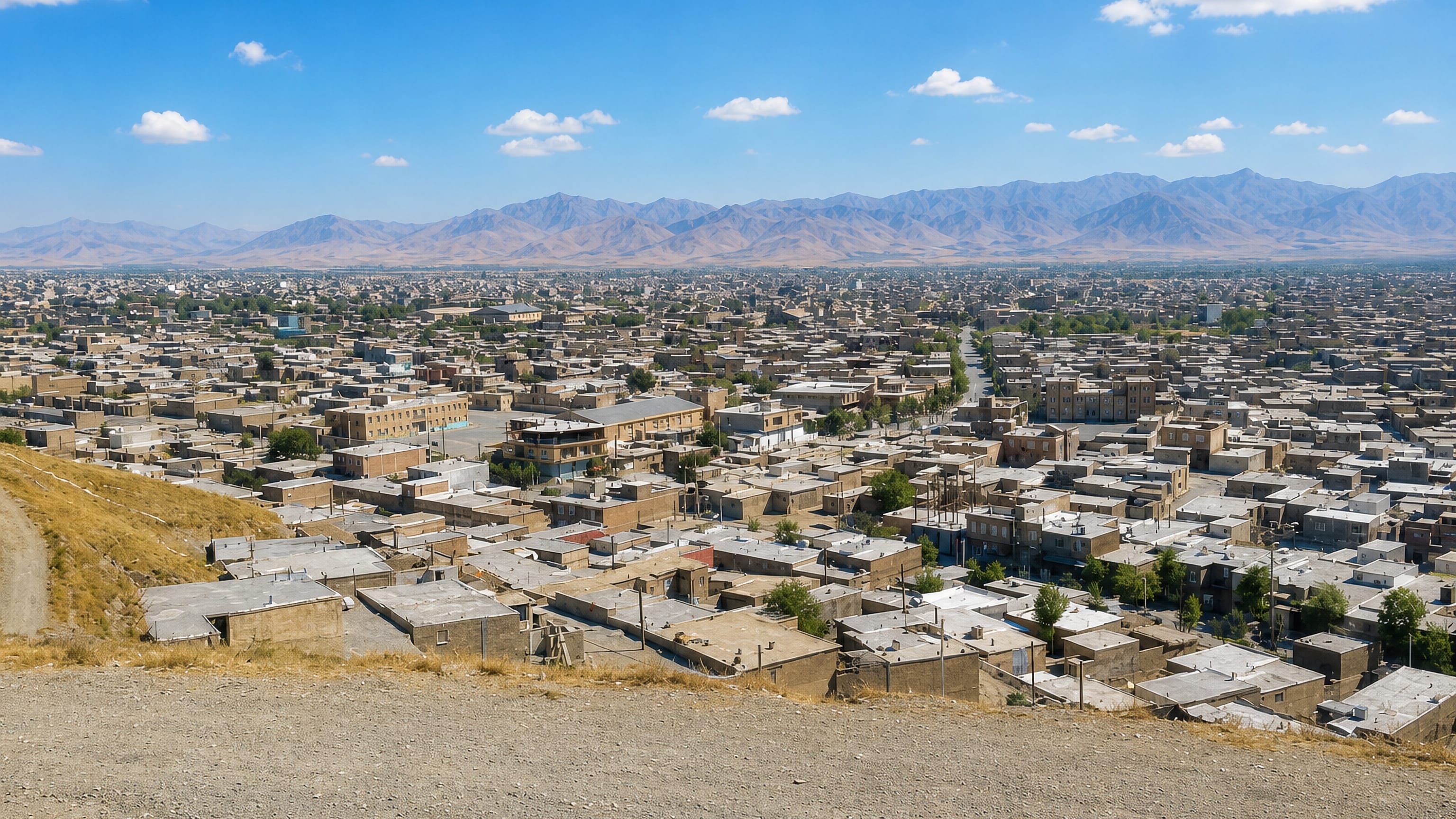 Flat-roofed houses of Piranshahr, Iran, spreading across a valley toward the arid Zagros mountains.