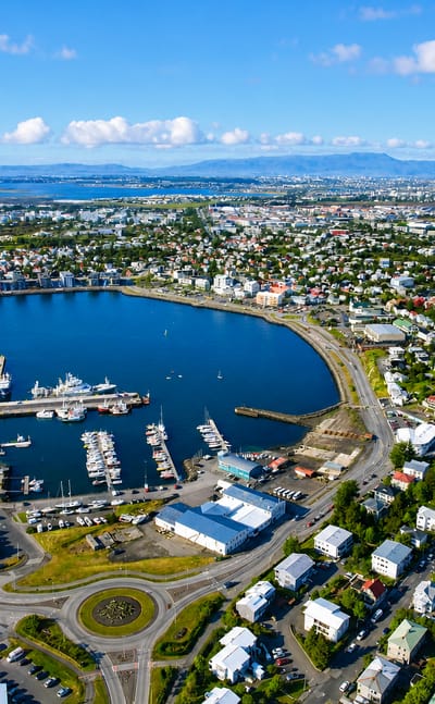 Aerial view of Hafnarfjörður, Iceland, showing its harbour, boat-filled marina and colourful coastal town beside the bay
