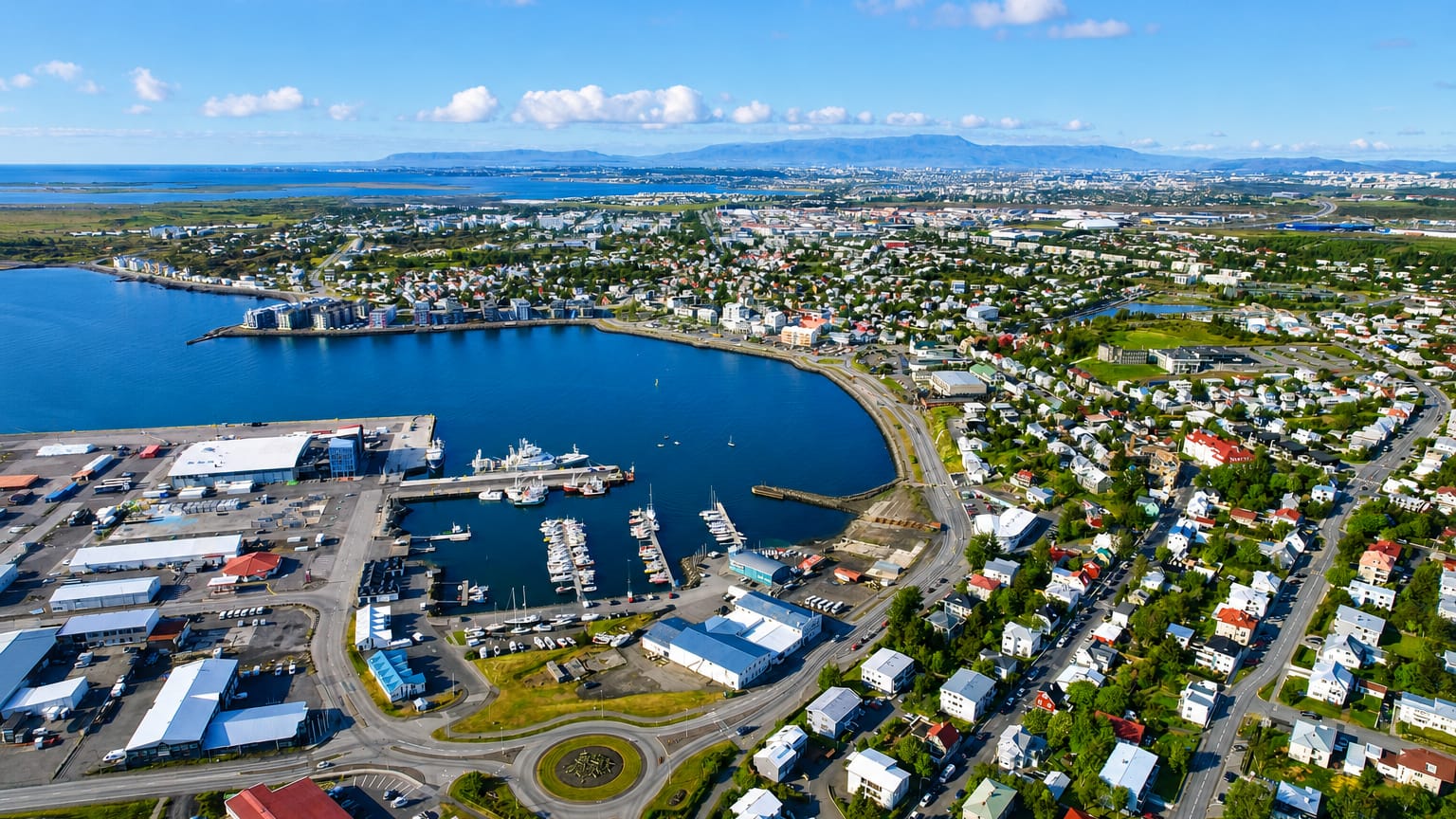 Aerial view of Hafnarfjörður, Iceland, showing its harbour, boat-filled marina and colourful coastal town beside the bay