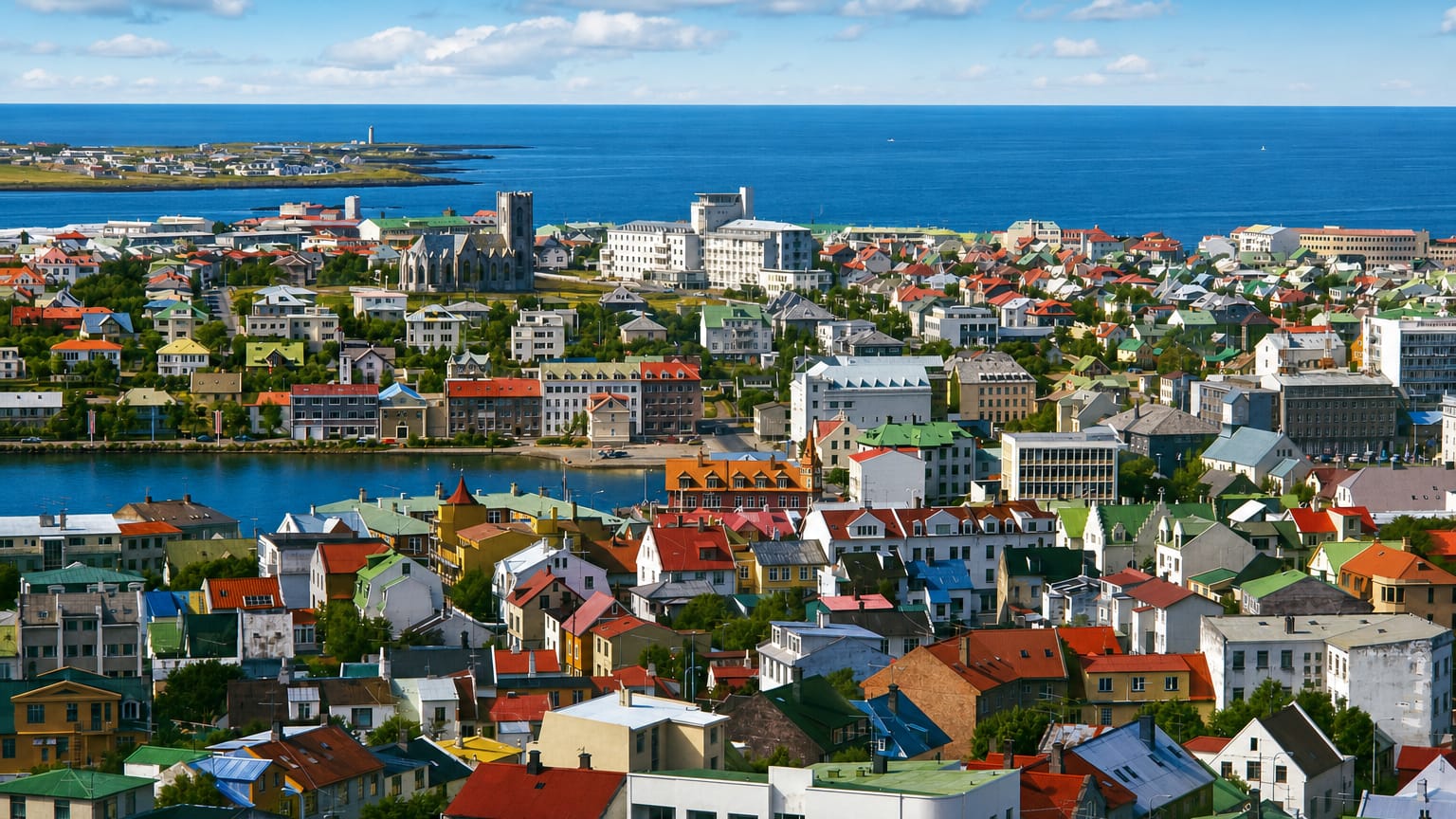 Elevated view across the colorful rooftops of Vesturbær in Reykjavík, toward the bay and the open Atlantic.