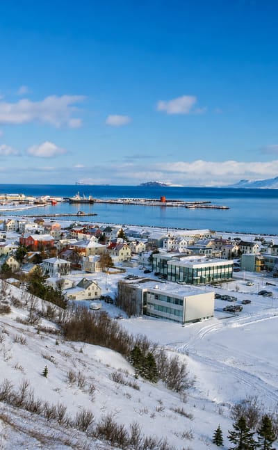 Elevated winter view over Sauðárkrókur, Iceland, with its harbour and the Skagafjörður fjord beneath snowy hills.