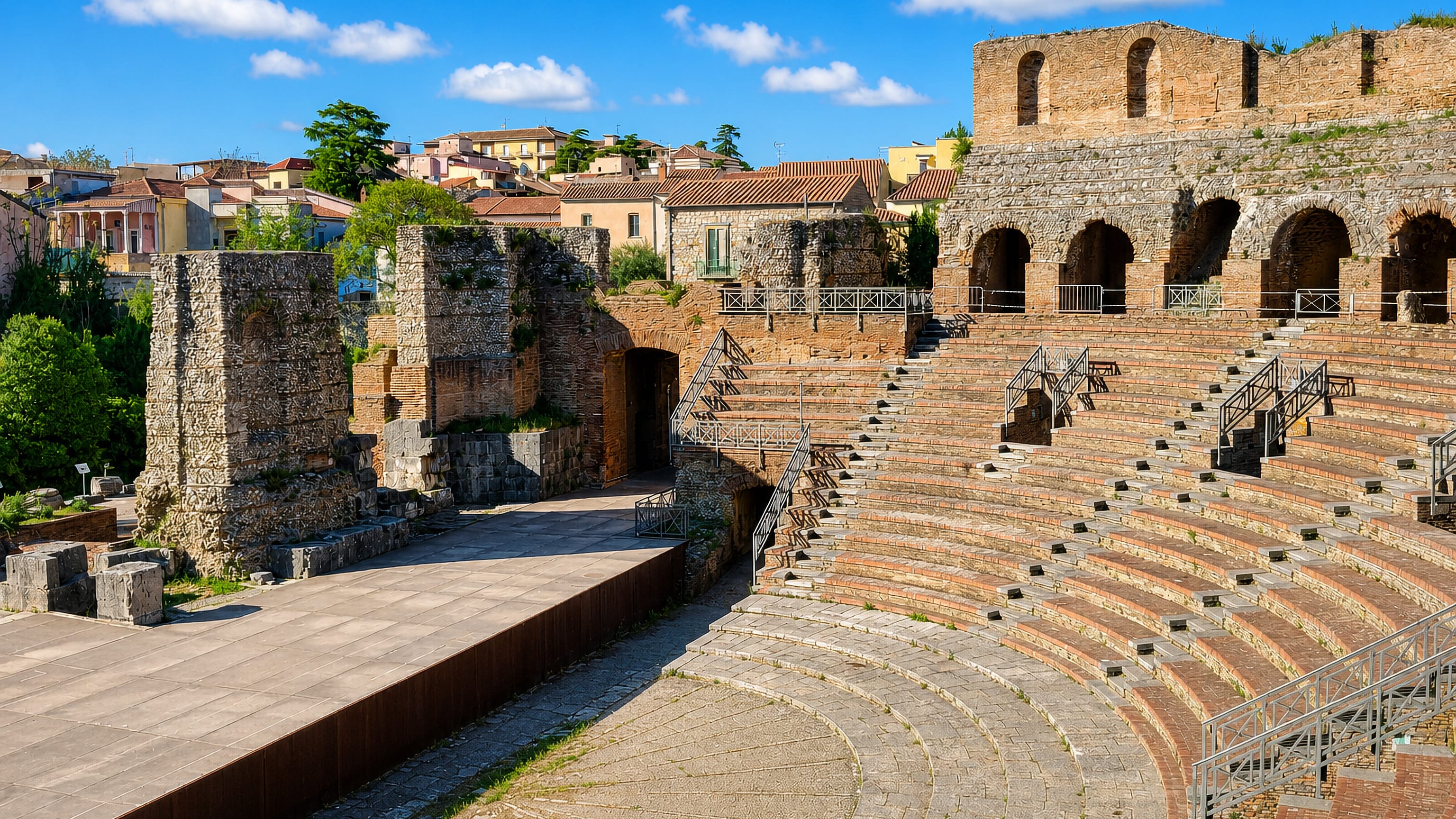 The Roman theatre of Benevento, Italy, its tiered stone seating below the hillside houses of the old town.