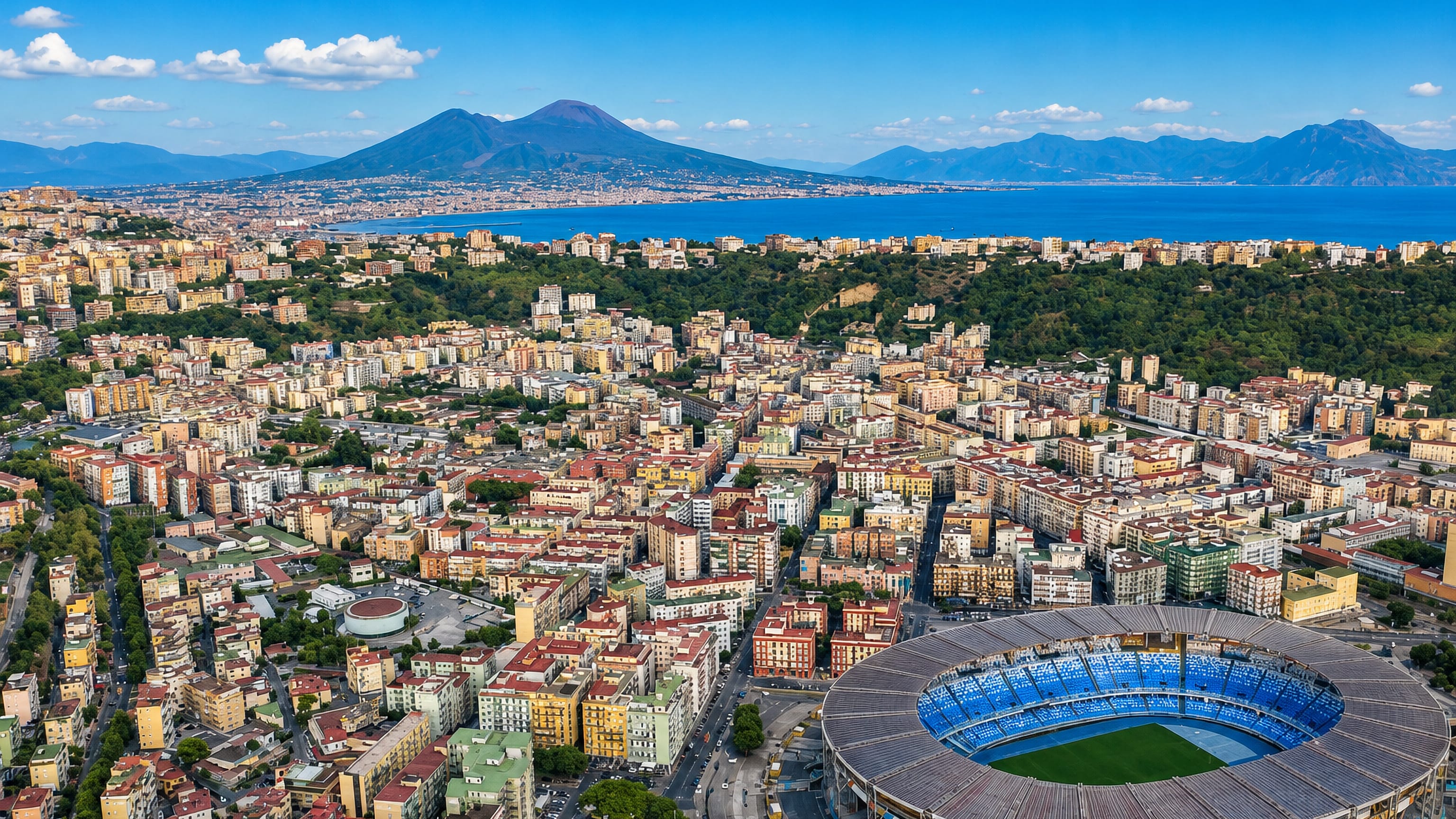 Aerial view over Fuorigrotta, Naples, with the Maradona stadium in the foreground and Vesuvius across the bay.
