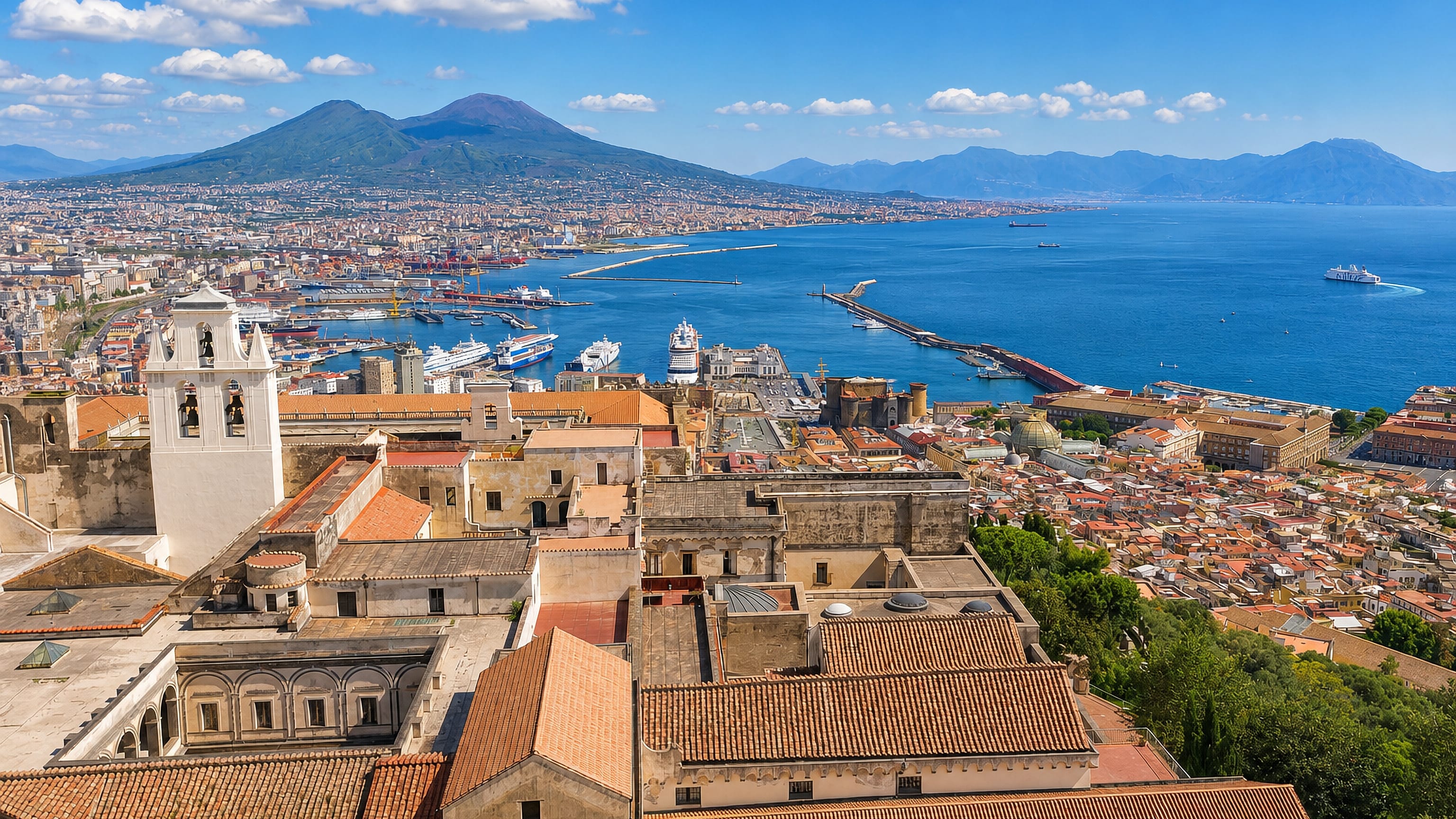 Naples rooftops and the Bay of Naples seen from Vomero, with Mount Vesuvius and the port beyond.