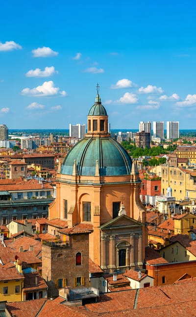 Bologna skyline with its leaning medieval Two Towers, a green-domed church and terracotta rooftops