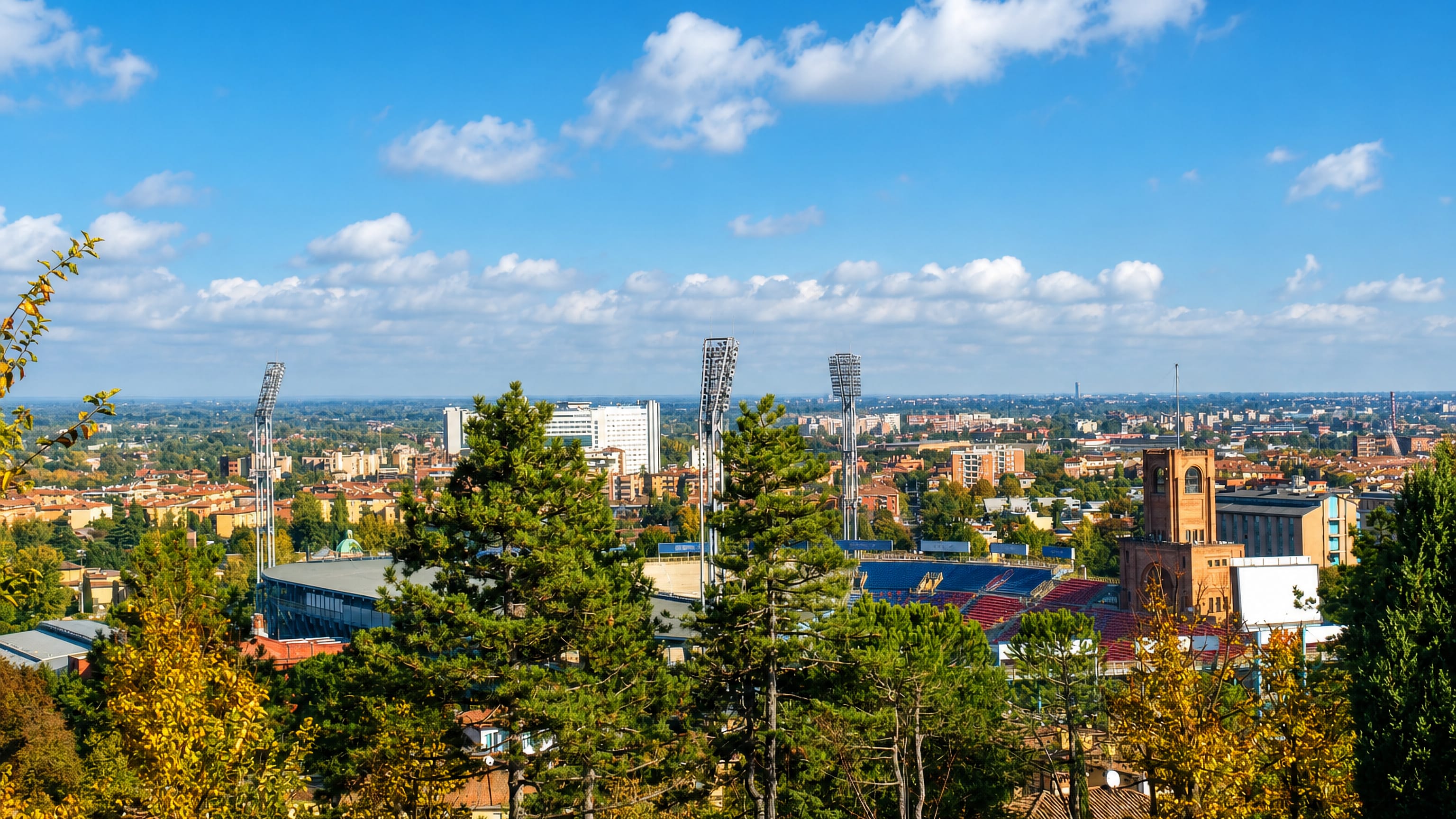 Bologna rooftops seen from the hills, with the Stadio Dall'Ara and its brick Marathon tower in Porto-Saragozza.